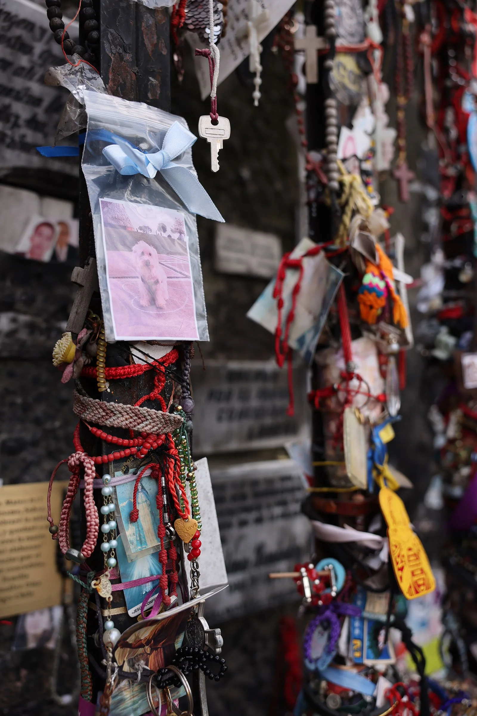 Personliga armband, nycklar och foton på en vägg uppe på Cerro San Cristobal i Santiago de Chile