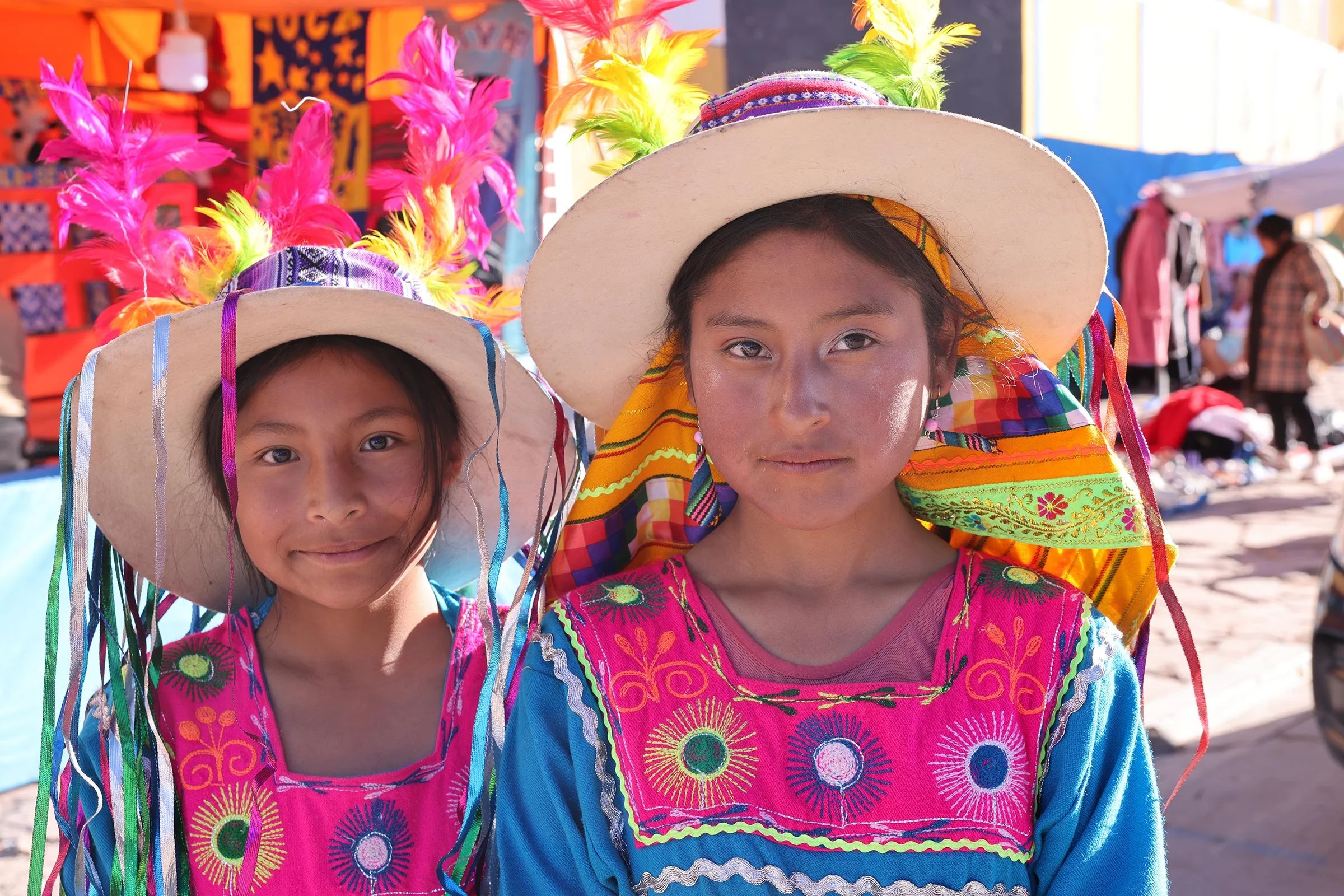 Två flickor i traditionella kläder i San Cristóbal Village, Bolivia