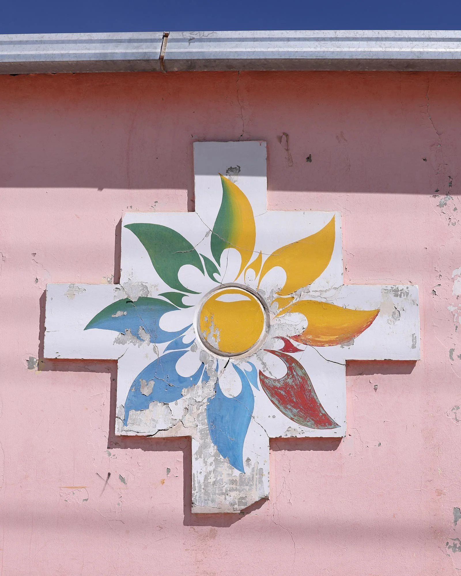 Färgglad blomma målad på en ljusrosa husfasad i staden Uyuni, Bolivia