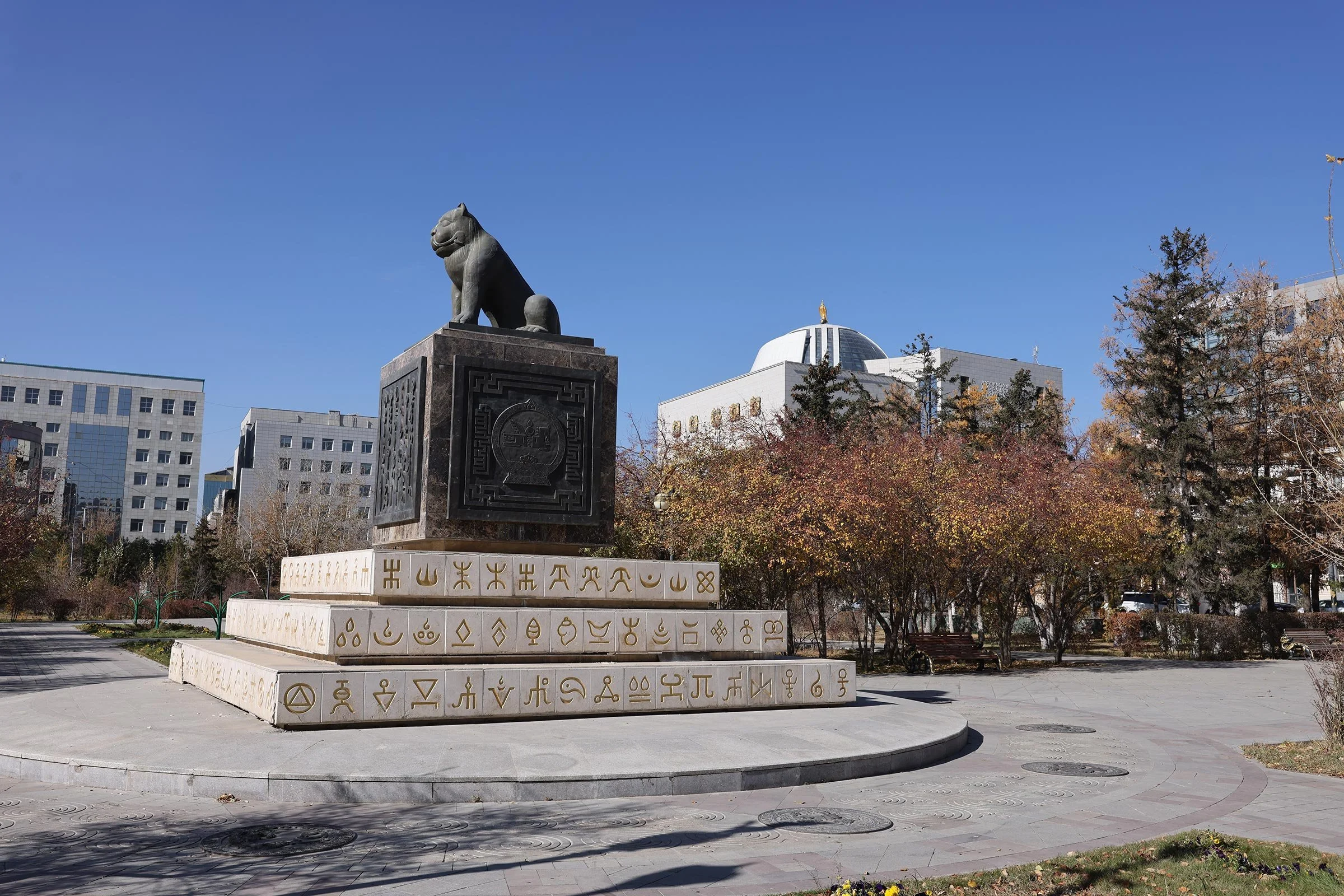 Monument över det mongoliska statssigillet med Chinggis Khaan National Museum of Mongolia i bakgrunden, Ulaanbaatar, Mongoliet