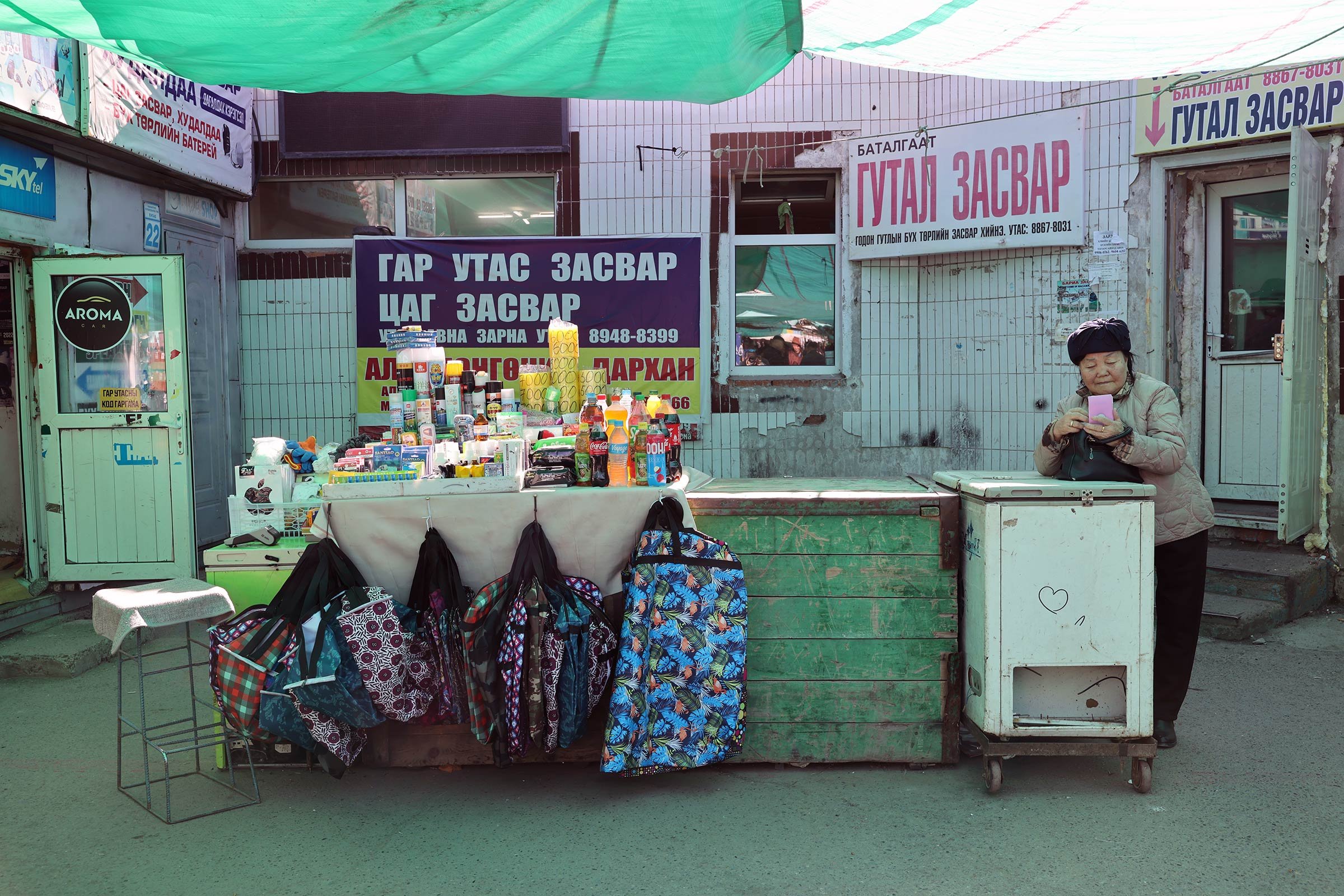 En äldre kvinna med en mobiltelefon på  Narantuul Market, Ulaanbaatar, Mongoliet
