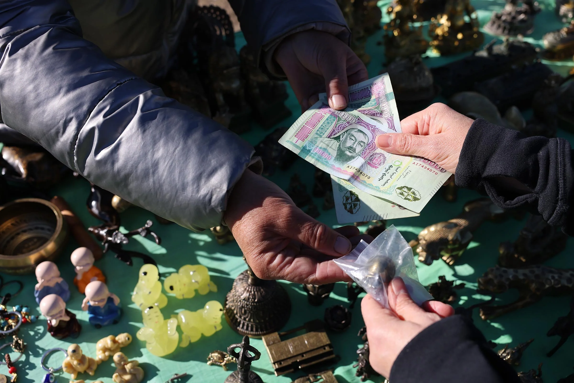Inköp av en liten sköldpadda i mässing på en marknad i Mongoliet, betalning med mongoliska tögrög