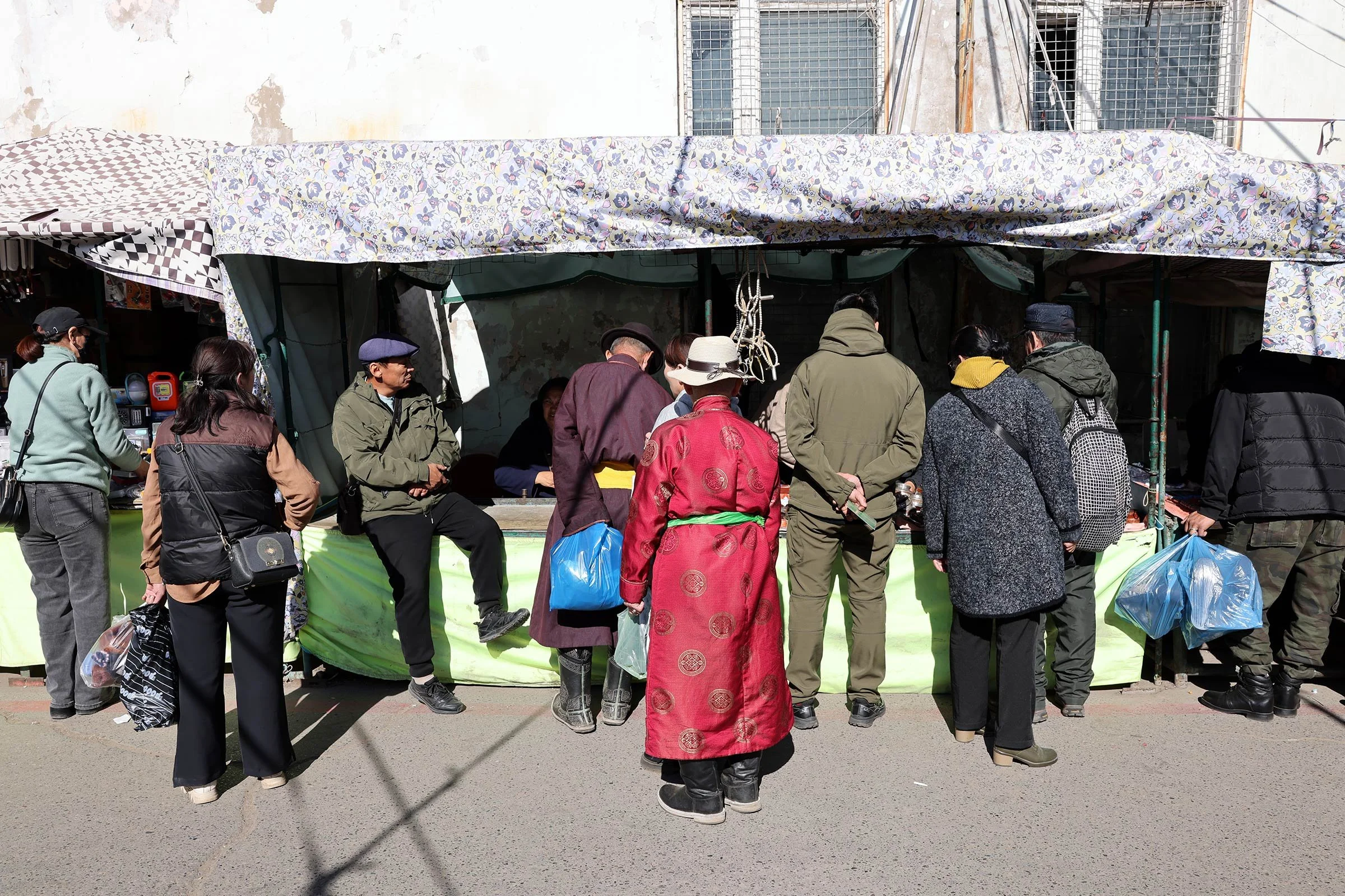 Människor framför ett marknadsstånd på  Narantuul Market, Ulaanbaatar, Mongoliet