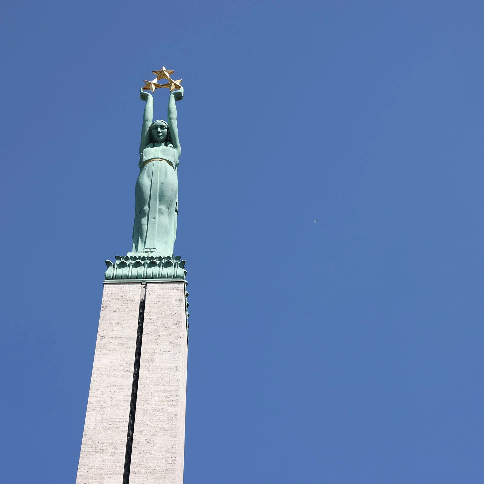 Frihetsmonumentet med kvinnan Milda som håller tre guldstjärnor, Riga, Lettland