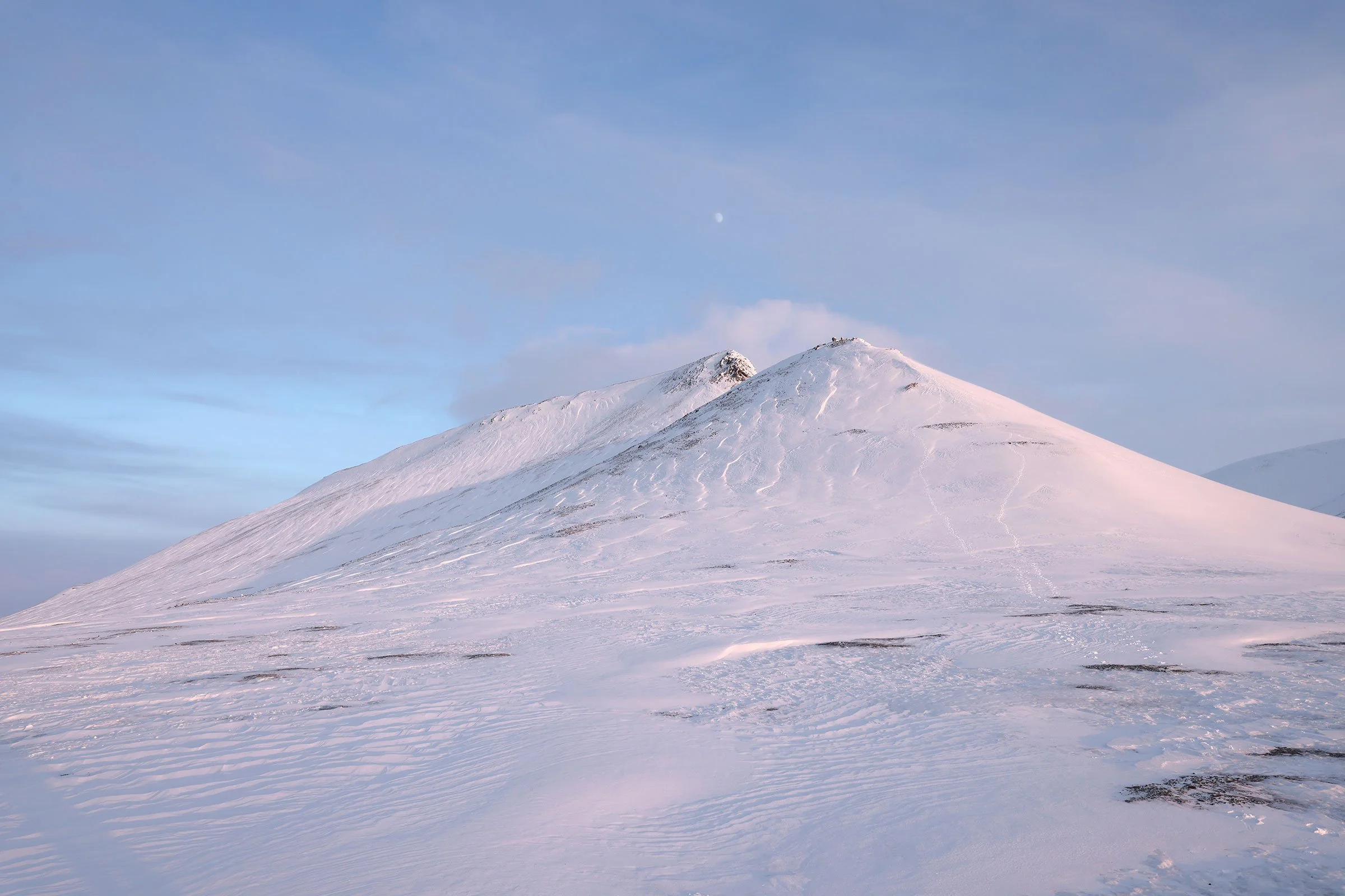 En snöklädd mindre topp i Blomsterdalen på Svalbard