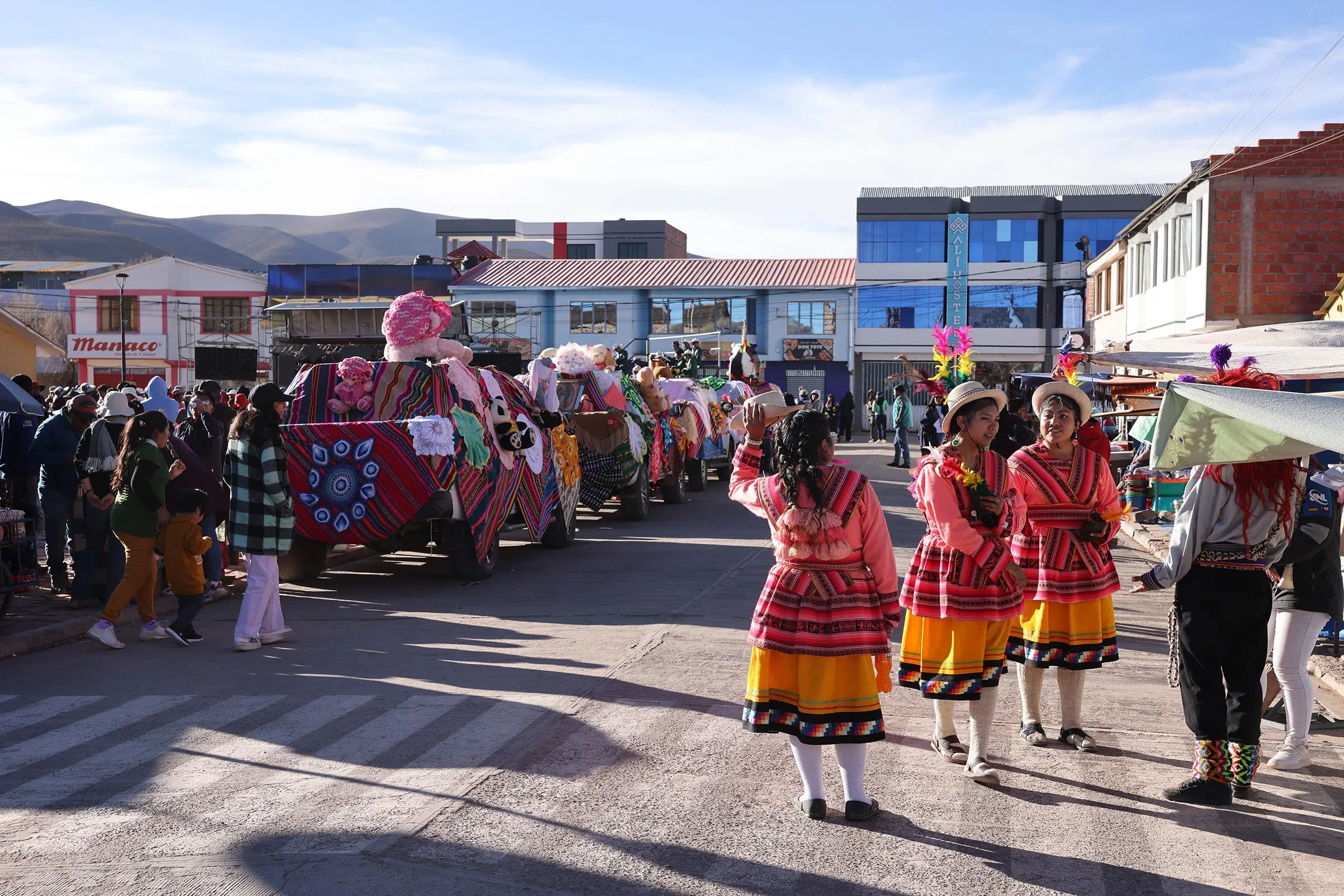 Festivalstämning med pyntade bilar och traditionella kläder i San Cristóbal Village, Bolivia