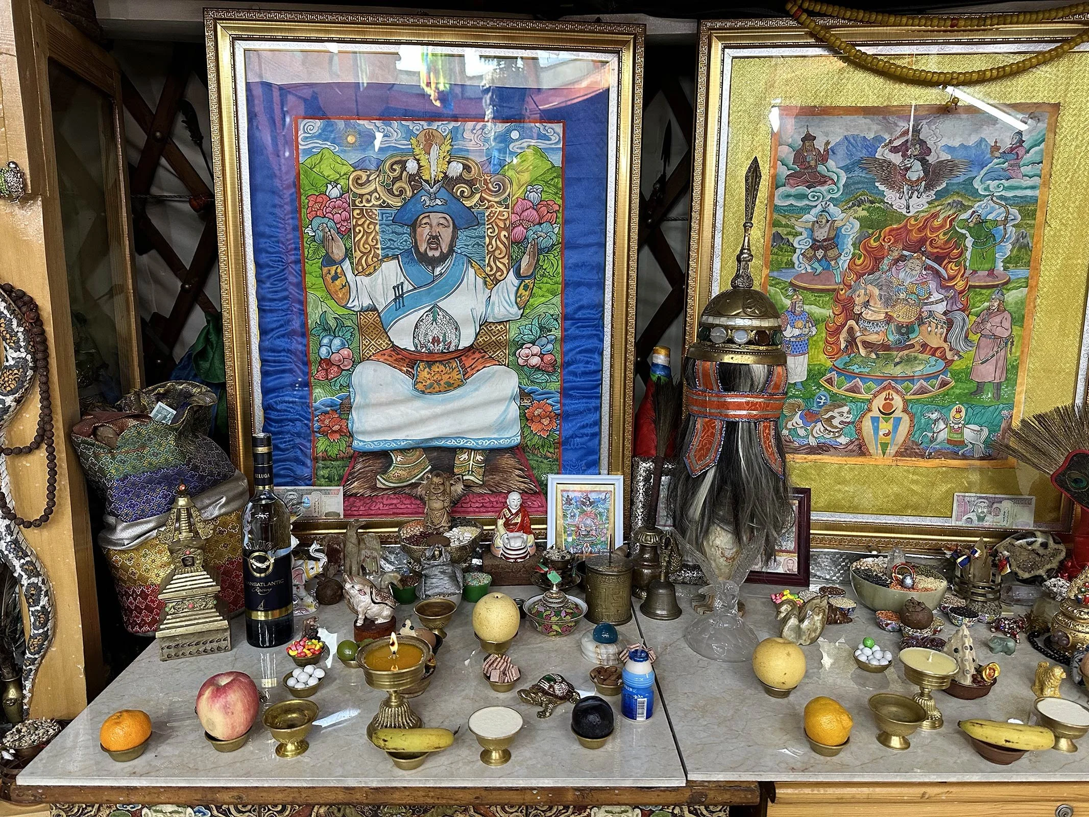 Små offergåvor och tavlor som står prydligt placerade på en bänk i en shaman-ger i Ulaanbaatar, Mongoliet