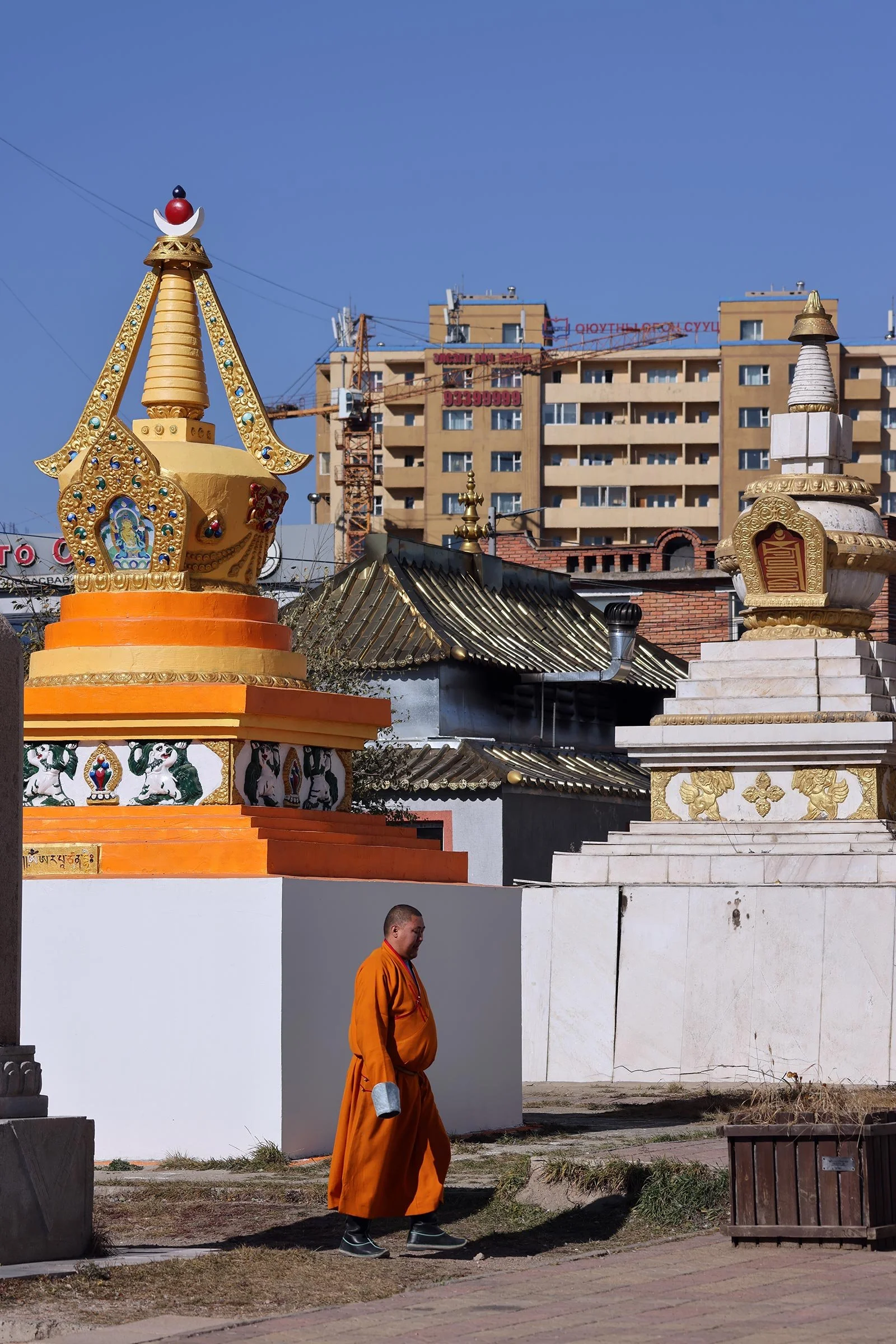 En munk i orange dräkt vid Gandantegchinlen-klostret (Gandan Khiid) i Ulaanbaatar, Mongoliet