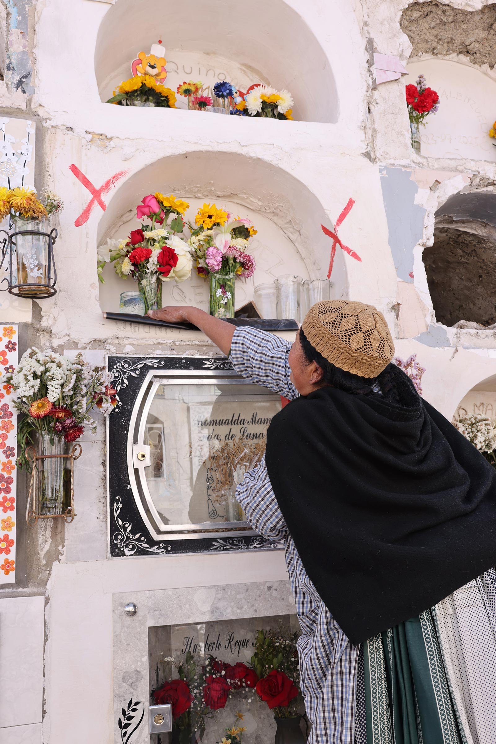 Kvinna som gör i ordning vid sin pappas grav på Cementerio General de La Paz, La Paz, Bolivia