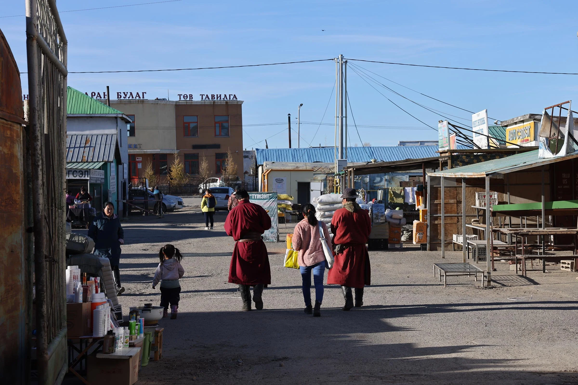 Människor i traditionella mongoliska kläder utanför black market i Kharkhorin, Mongoliet