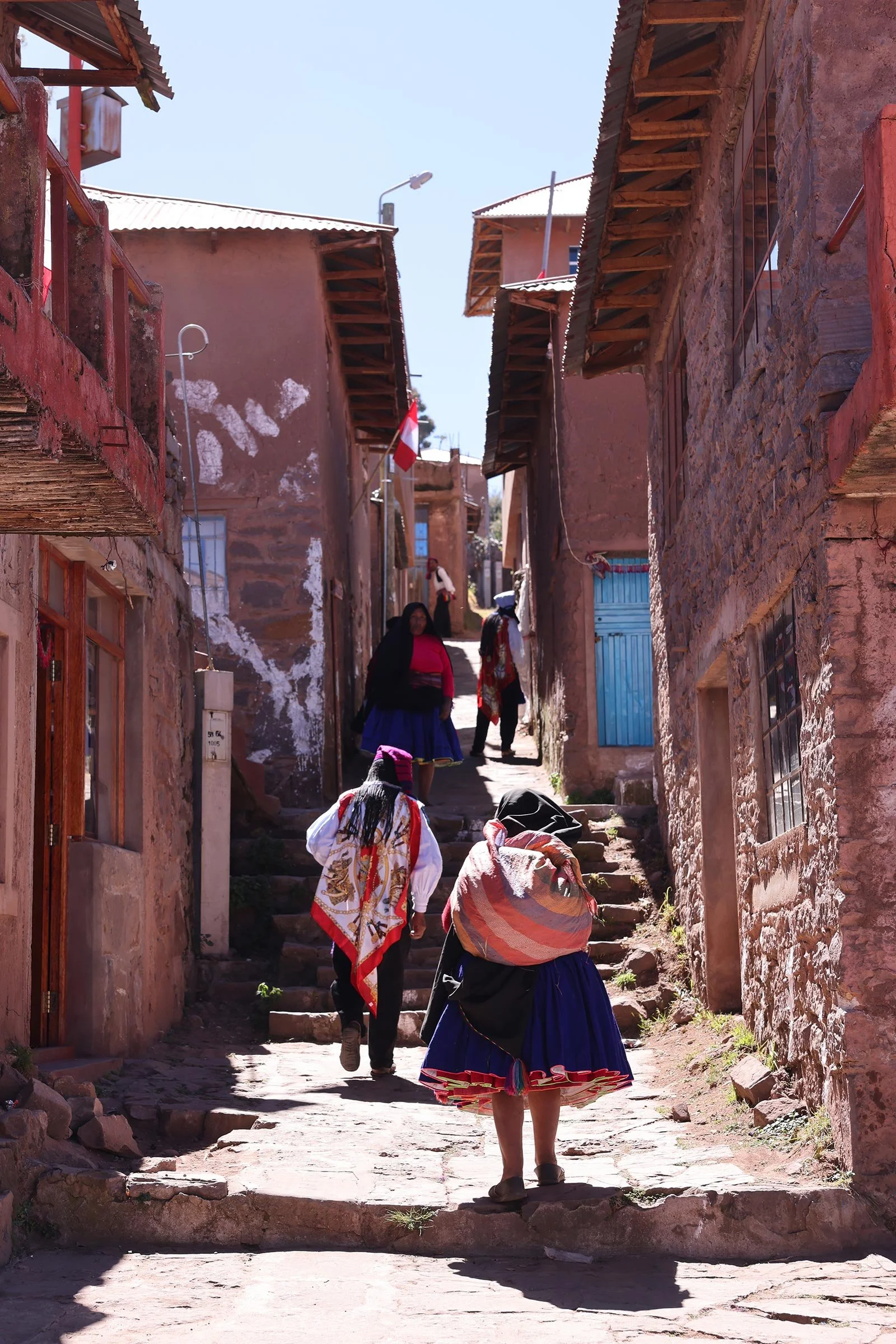 Taquileños i de steniga gränderna vid torget på ön Taquile i Titicacasjön, Peru