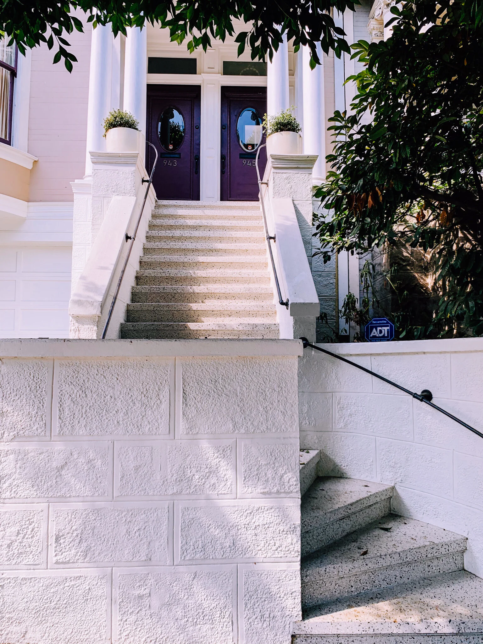 Building is parallel to the street with the stoop, porch, and main entrance facing the street and sidewalk. Porch and stoop project out beyond the building line. Porch and main entrance are above the level of the sidewalk.