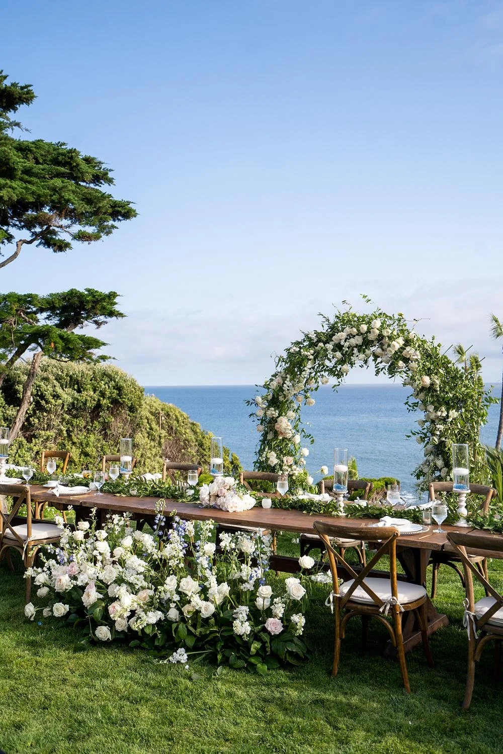 Wedding reception head table with ocean views and floral décor at Cypress Sea Cove