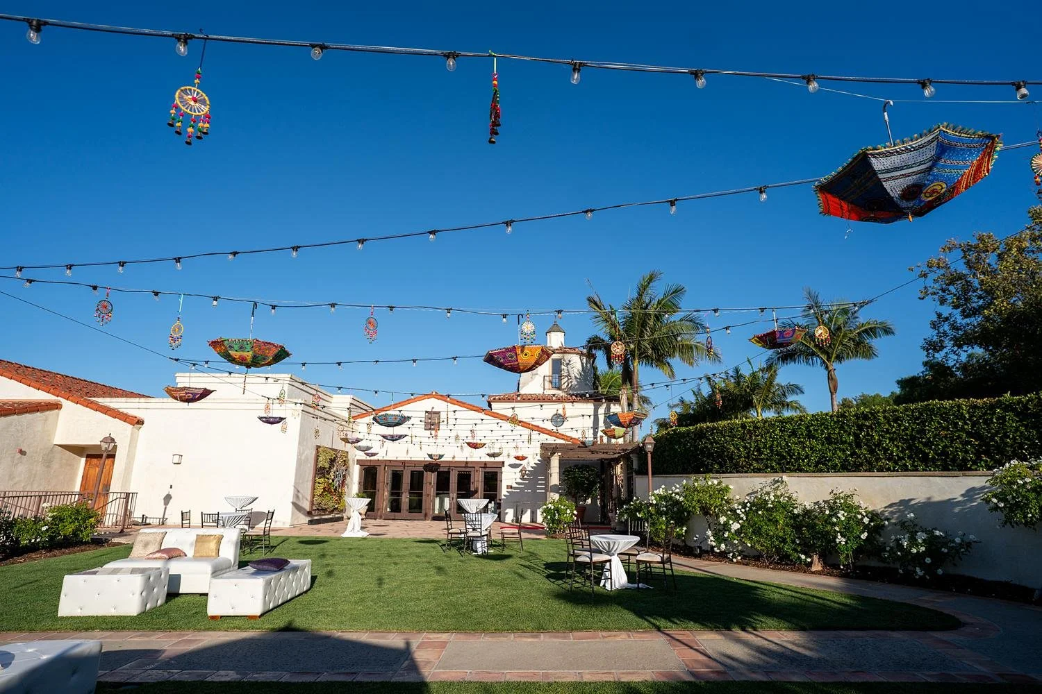 Wedding cocktails on the clubhouse lawn at Palos Verdes Golf Club with colorful umbrellas