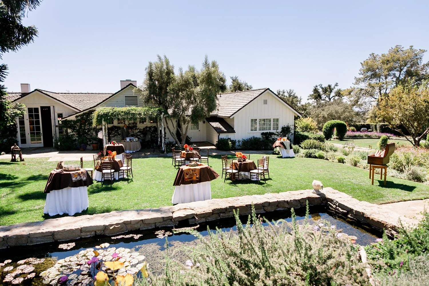 Wedding cocktails in Lower Garden with tables in front of Koi Pond at San Ysidro Ranch