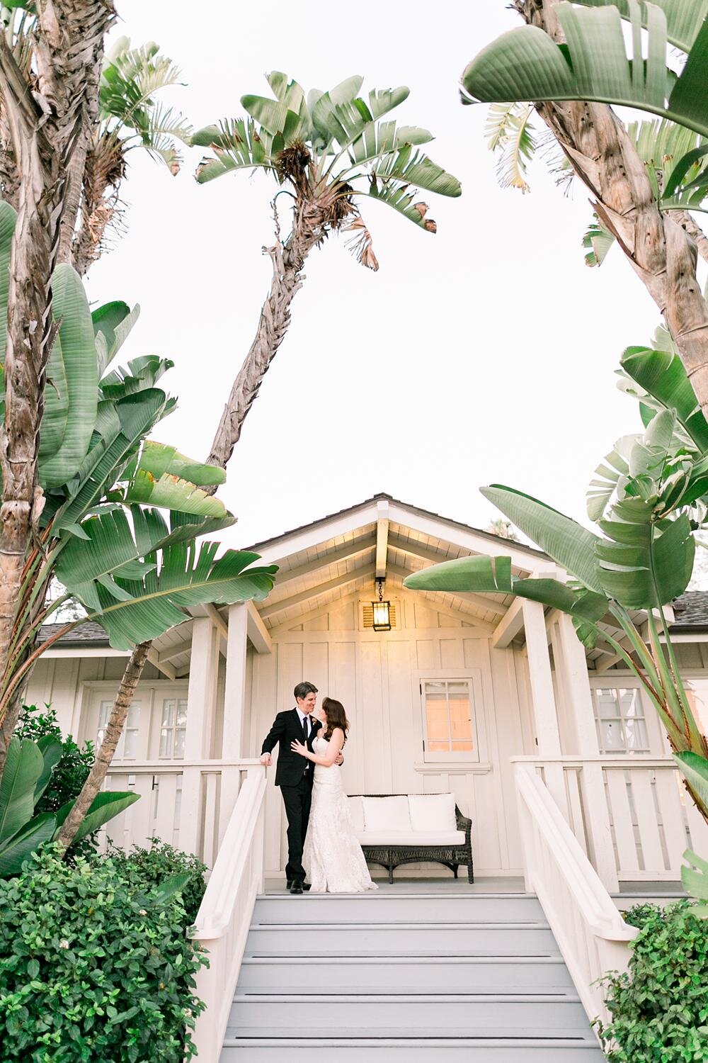 Wedding portraits of bride and groom at bungalows framed by palms at Belmond El Encanto