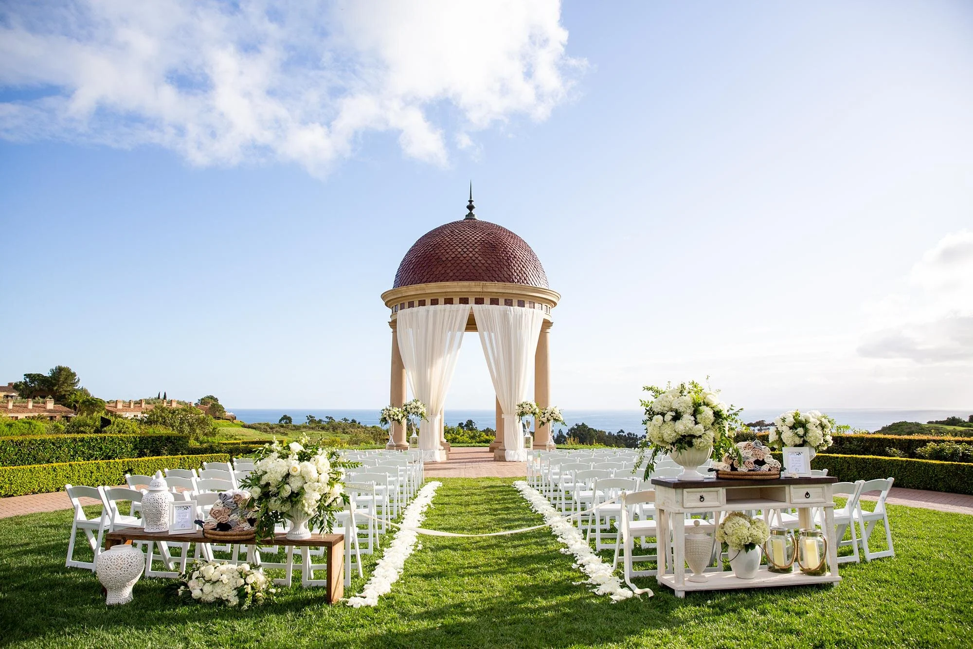 Event lawn wedding ceremony with white florals and ocean backdrop at Pelican Hill