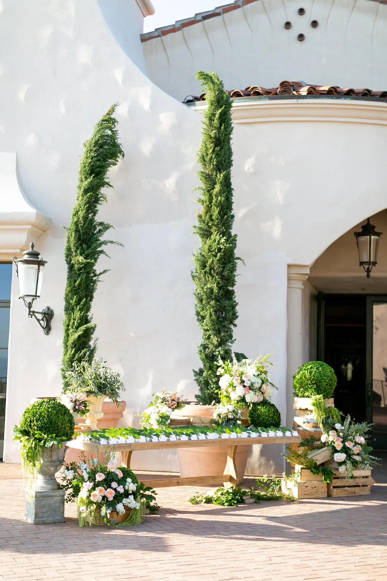 Detail of escort card table decorated with topiaries and pastel florals at Pelican Hill wedding reception