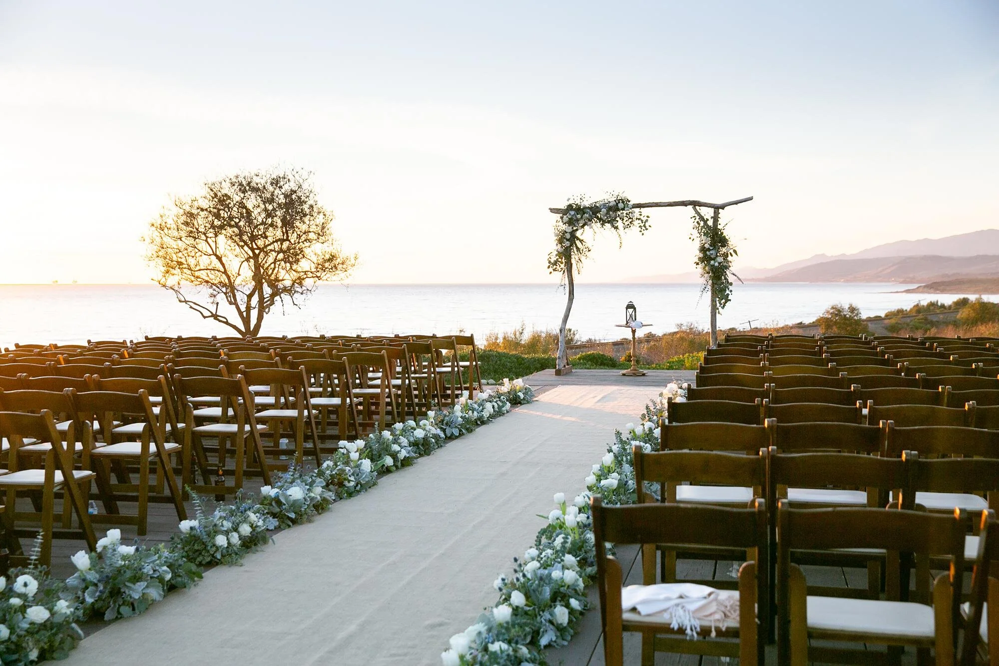 Wedding ceremony at sunset overlooking the ocean and coastline at Dos Pueblos Orchid Farm