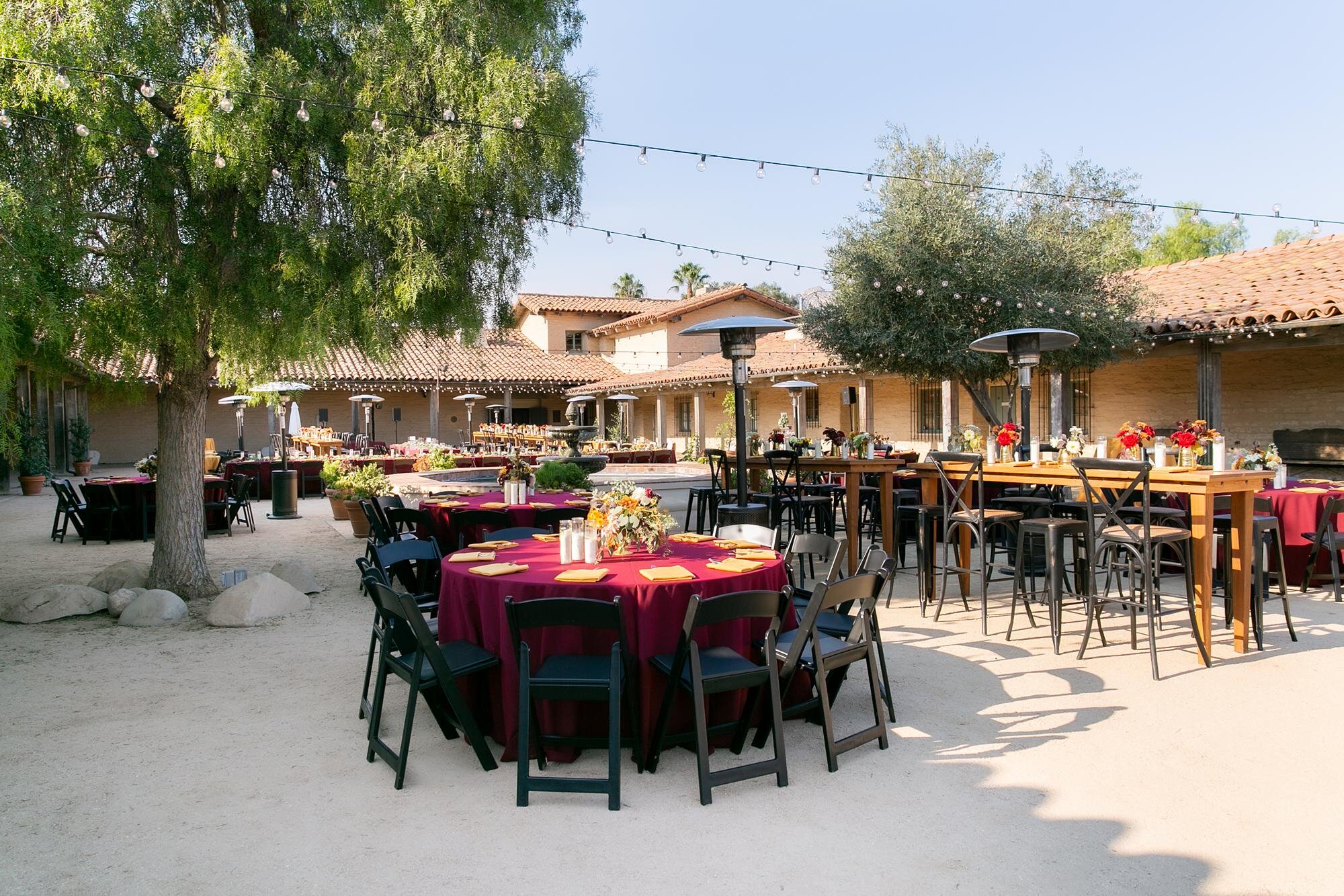 Wedding reception tables with floral centerpieces in the Courtyard at Santa Barbara Historical Museum