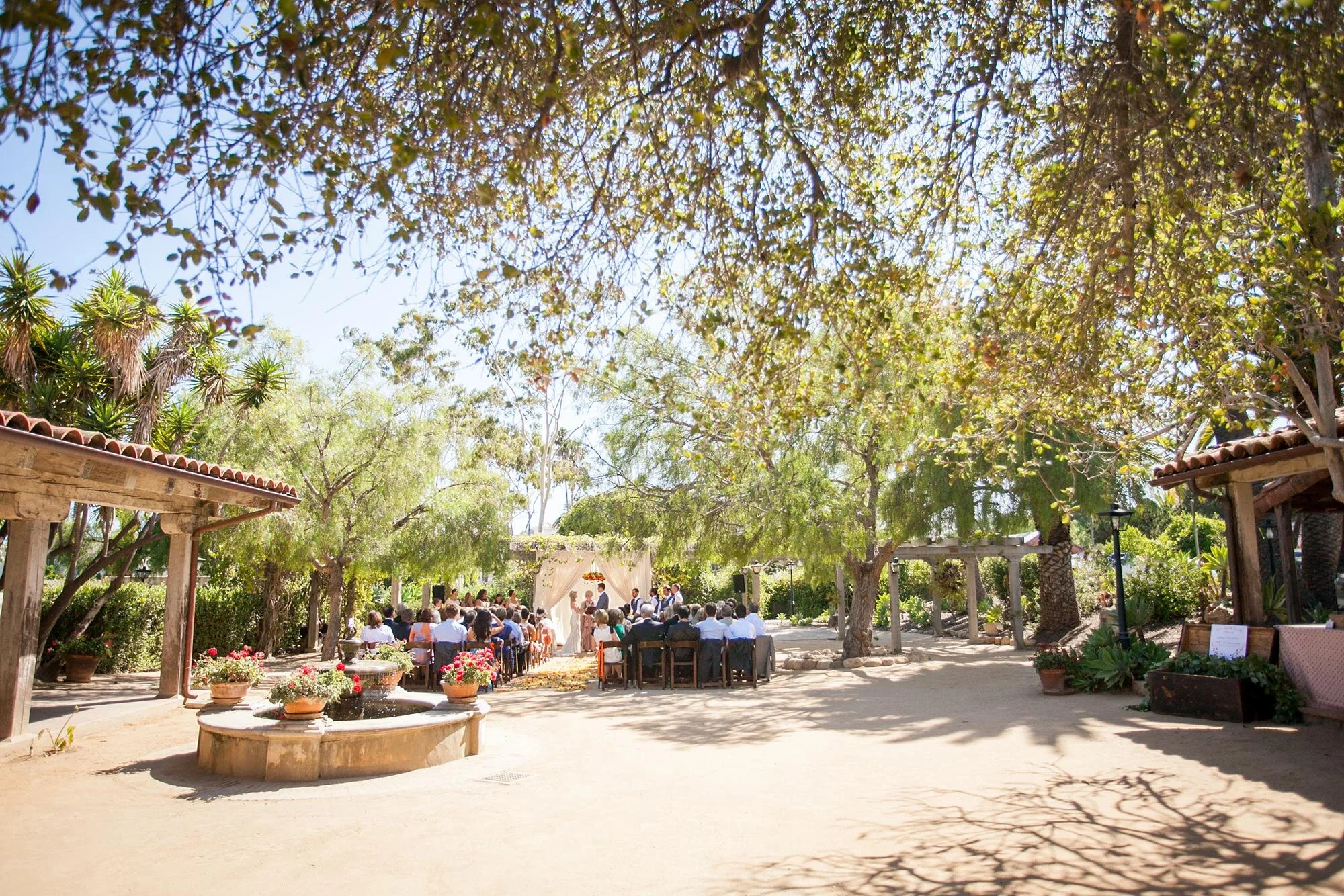 Wedding ceremony guests watching vows in the Santa Barbara Historical Museum Adobe Courtyard