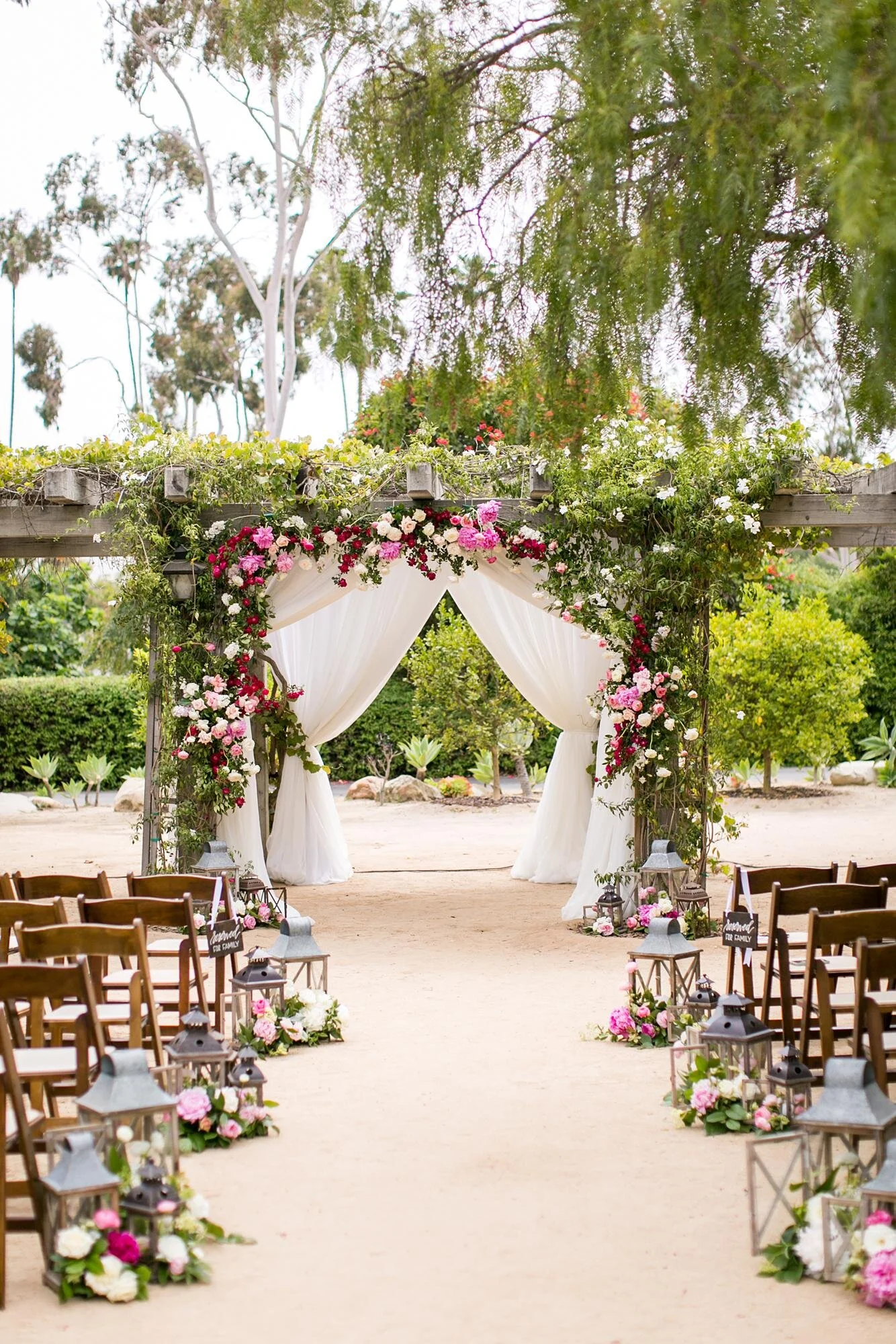 Wedding ceremony arch with cascading florals and drapery in the Santa Barbara Historical Museum Adobe Courtyard