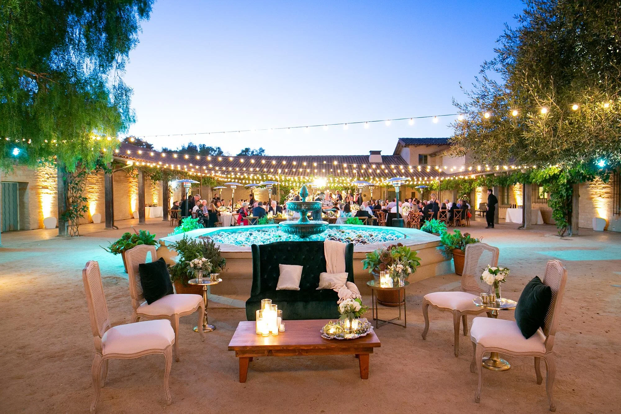 Wedding reception lounge area in front of fountain during evening celebration at Santa Barbara Historical Museum