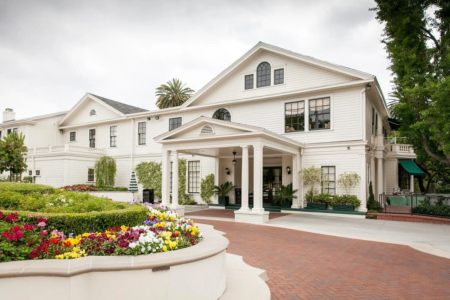 Wedding cocktail hour with blue tables set in front of the Valley Hunt Club