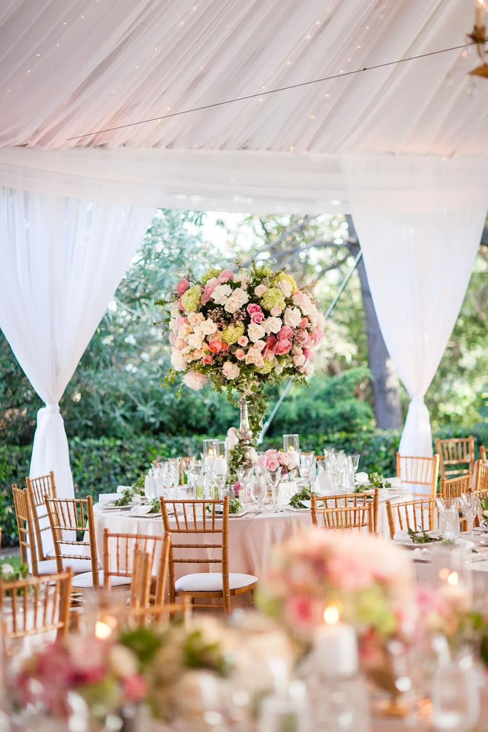 Wedding reception décor featuring a tall pink and white floral centerpiece at Annandale Golf Club