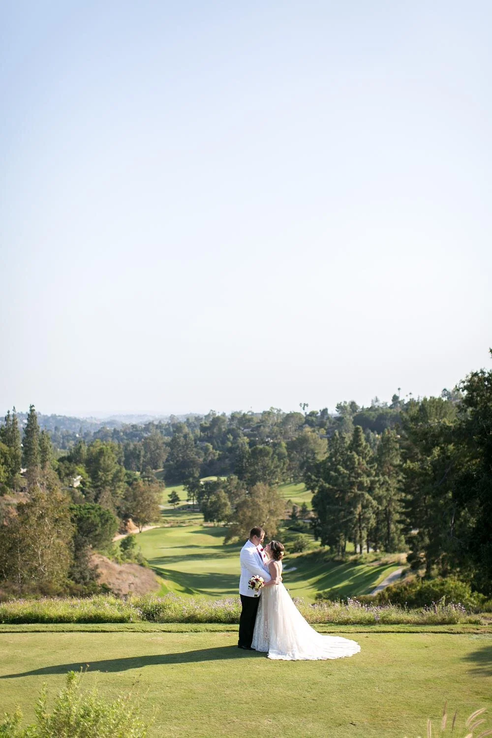 Wedding portraits of couple looking at each other at Annandale Golf Club with golf course backdrop