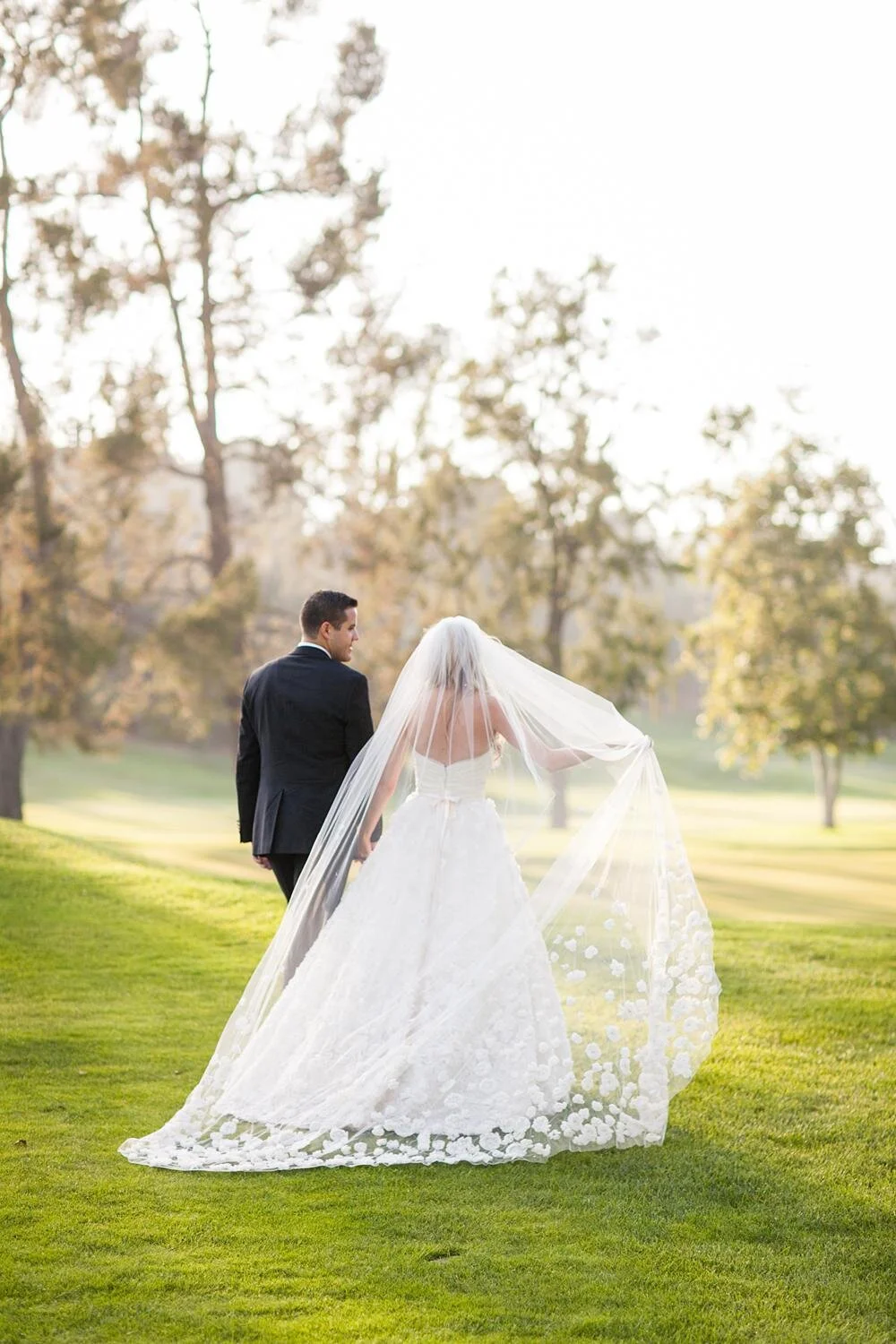 Wedding portrait of bride and groom walking at sunset on the golf course at Annandale Golf Club