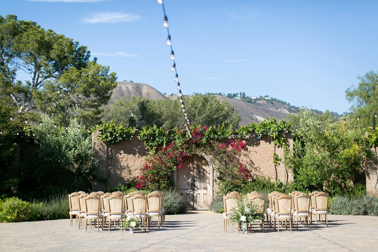 Wedding ceremony set before wooden doors with guests seated at Catalina View Gardens