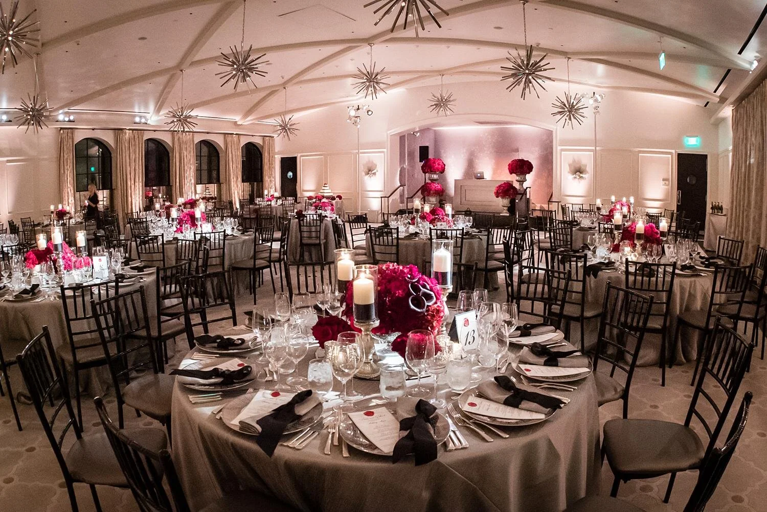 Wedding reception in the Garden Ballroom at Hotel Bel Air with red floral centerpieces and candlelight