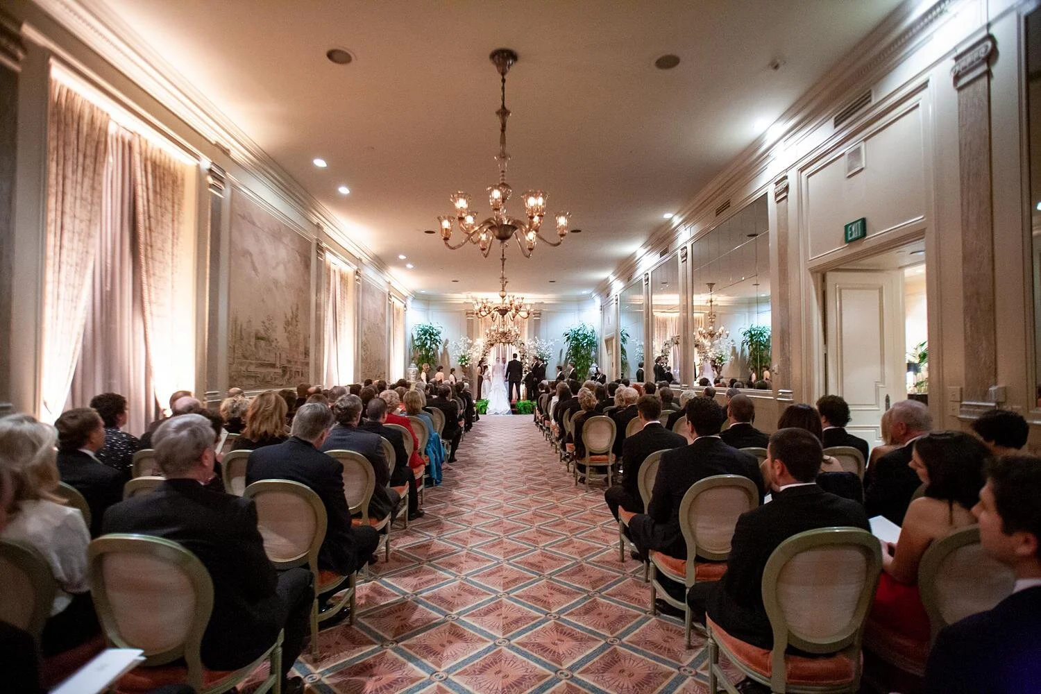 Wedding ceremony as guests watch couple exchange vows in the Second Floor Dining Room at the California Club