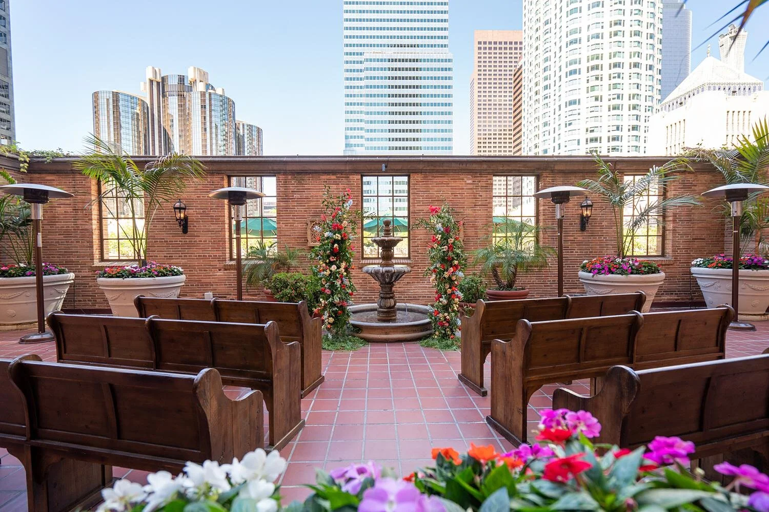 Wedding ceremony on the third floor patio at the California Club with fountain and skyline backdrop