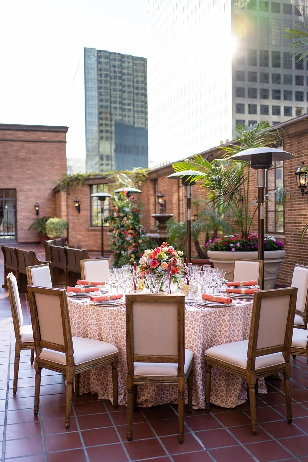 Wedding reception table detail with orange centerpieces on the third floor patio at the California Club