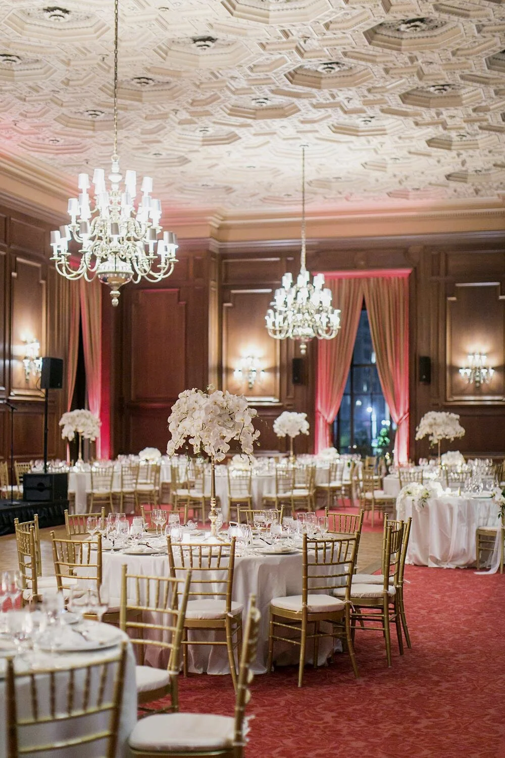 Wedding reception table featuring tall white orchid arrangements in the Main Dining Room at the California Club