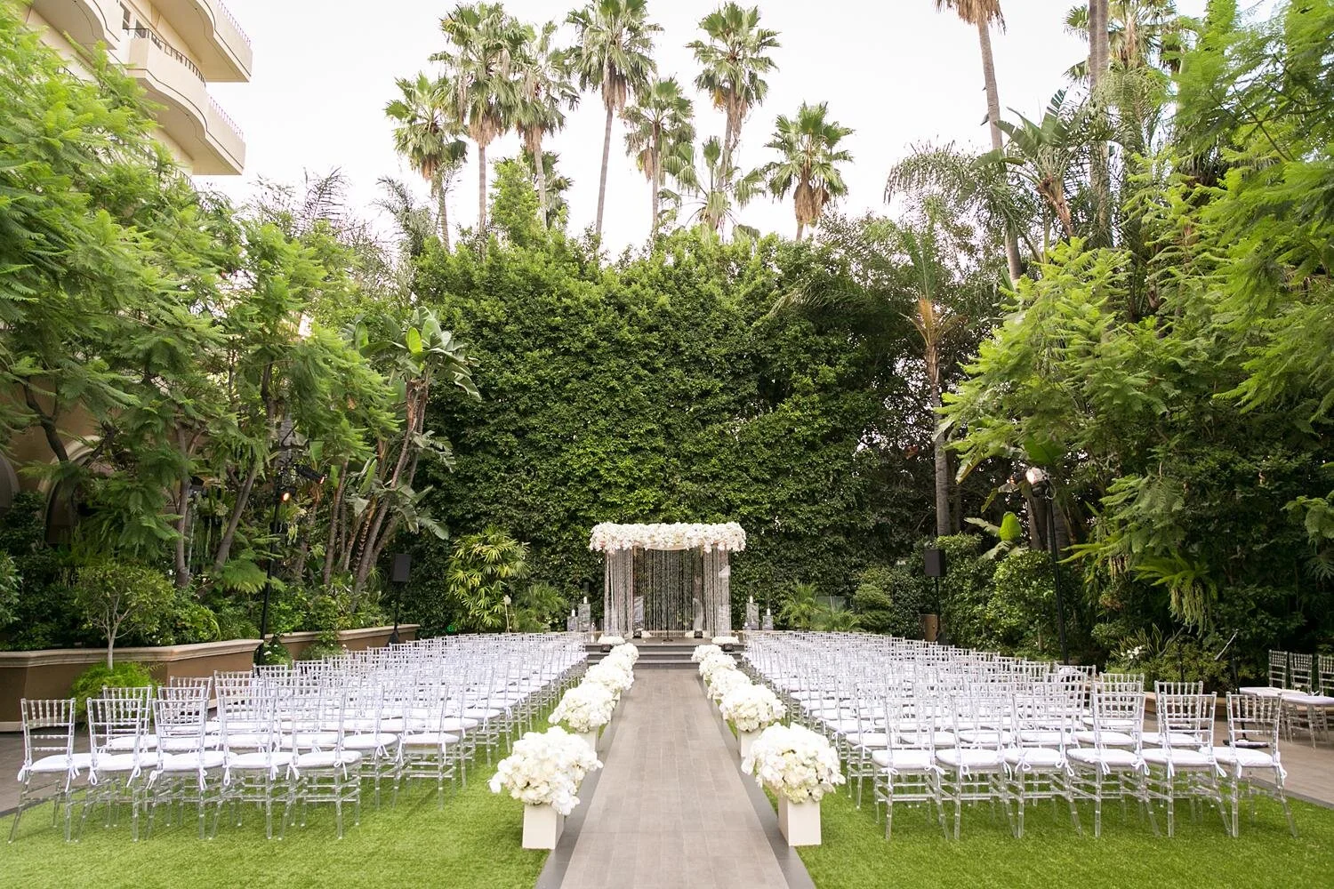 Wide view of a wedding ceremony in Weatherly Gardens during the afternoon at the Four Seasons Los Angeles