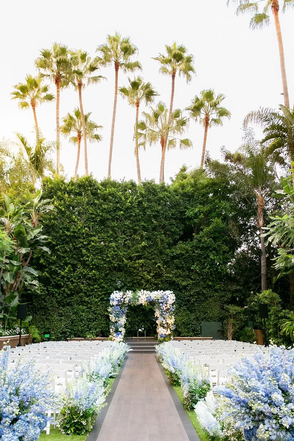 Wedding ceremony in Weatherly Gardens featuring romantic blue florals at the Four Seasons Los Angeles