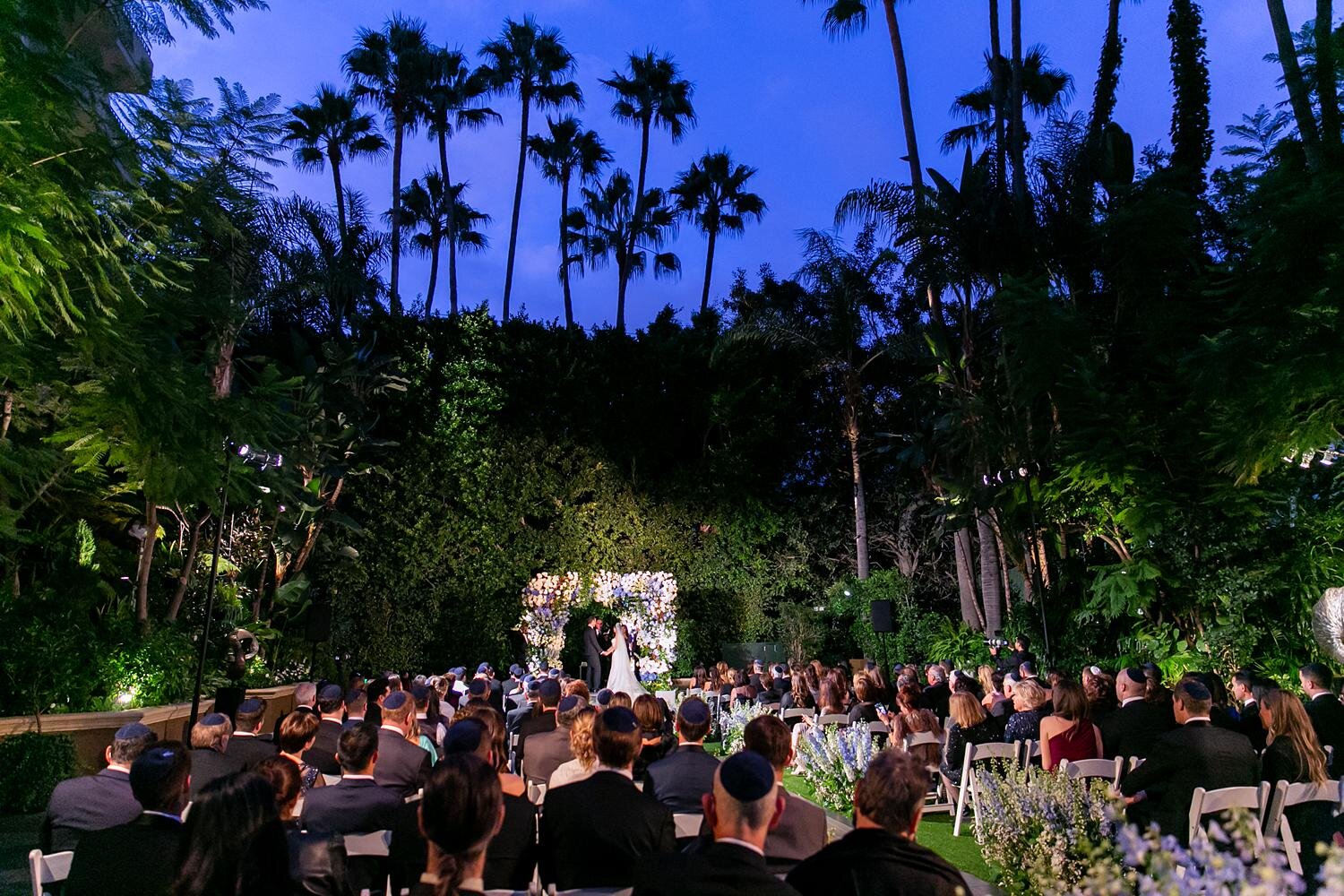 Bride and groom exchanging vows during a wedding ceremony in Weatherly Gardens at Four Seasons Los Angeles
