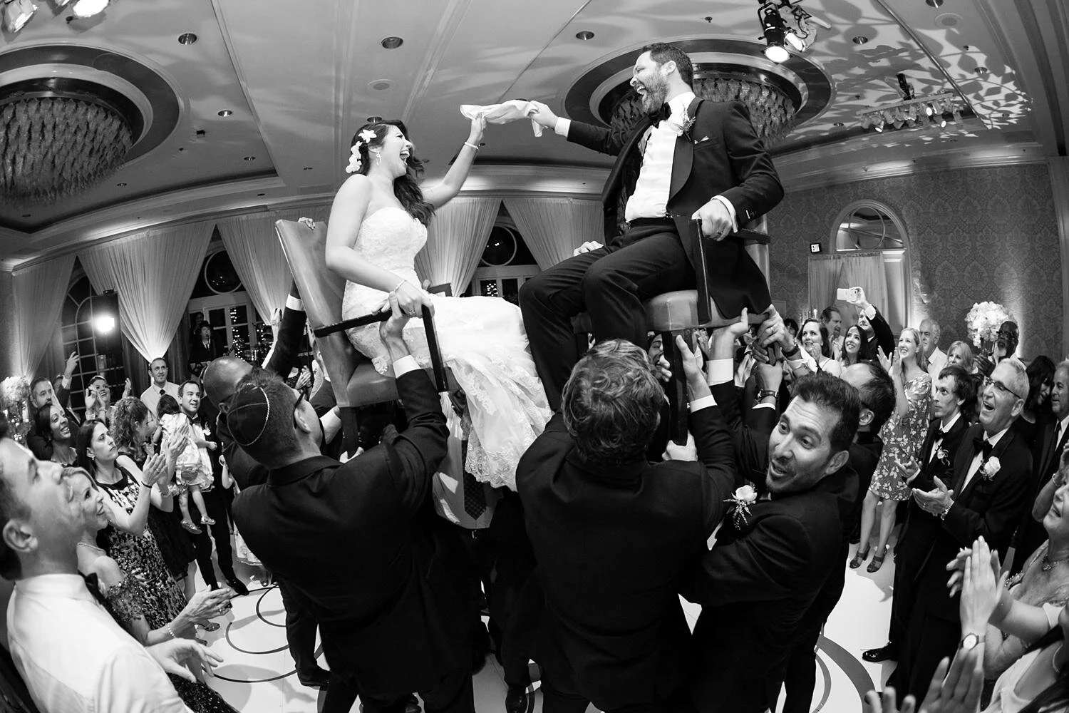 Bride and groom lifted during the hora at a ballroom wedding reception at the Four Seasons Los Angeles
