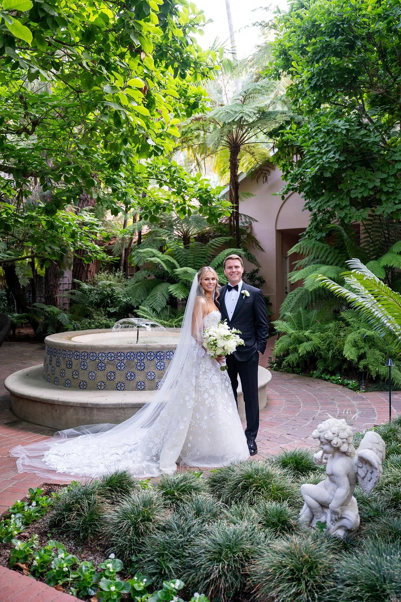 Wedding portraits of bride and groom posing beside the courtyard fountain at Hotel Bel Air