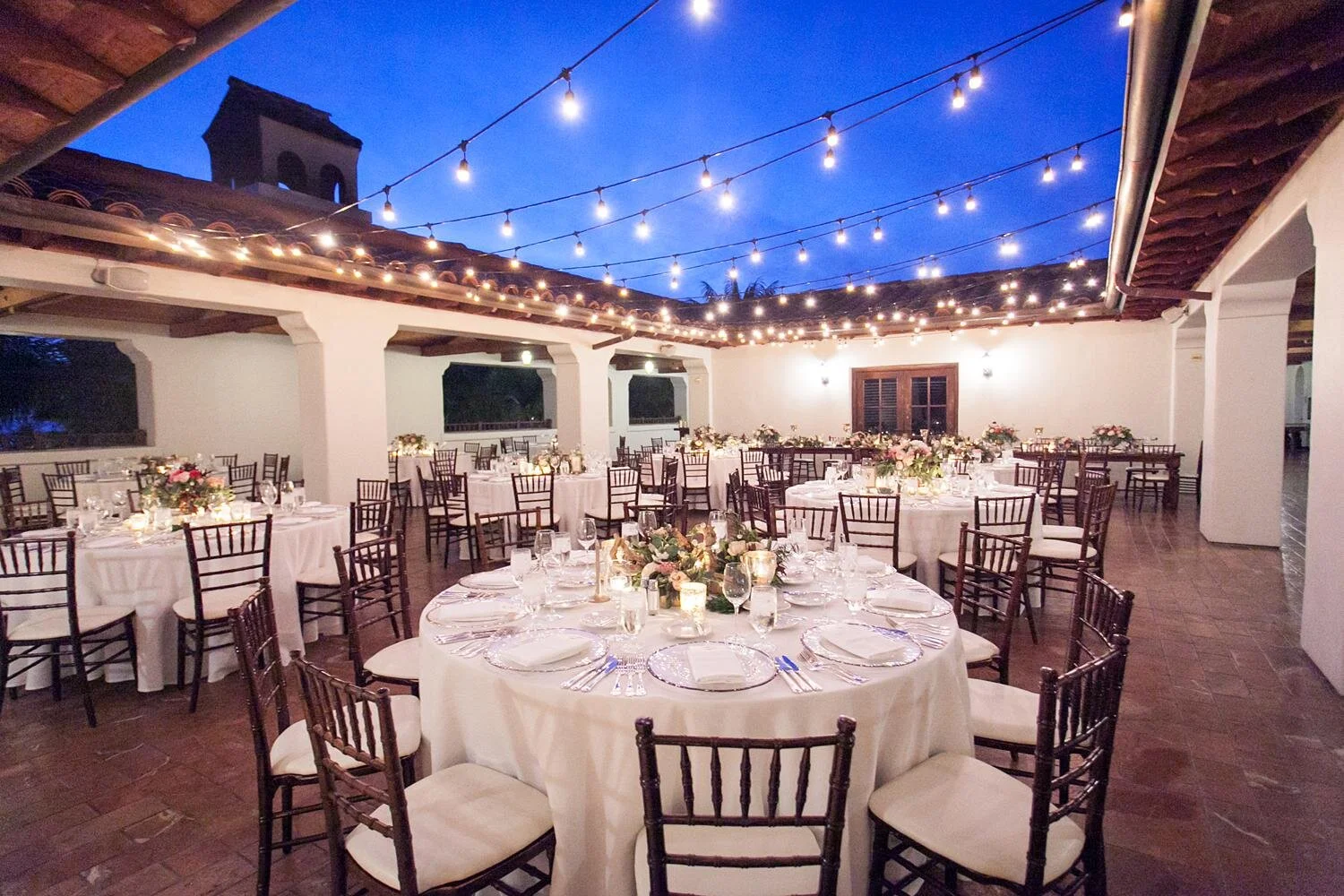 Wedding reception at sunset under hanging lights on the Rotunda Patio at Ritz Carlton Bacara