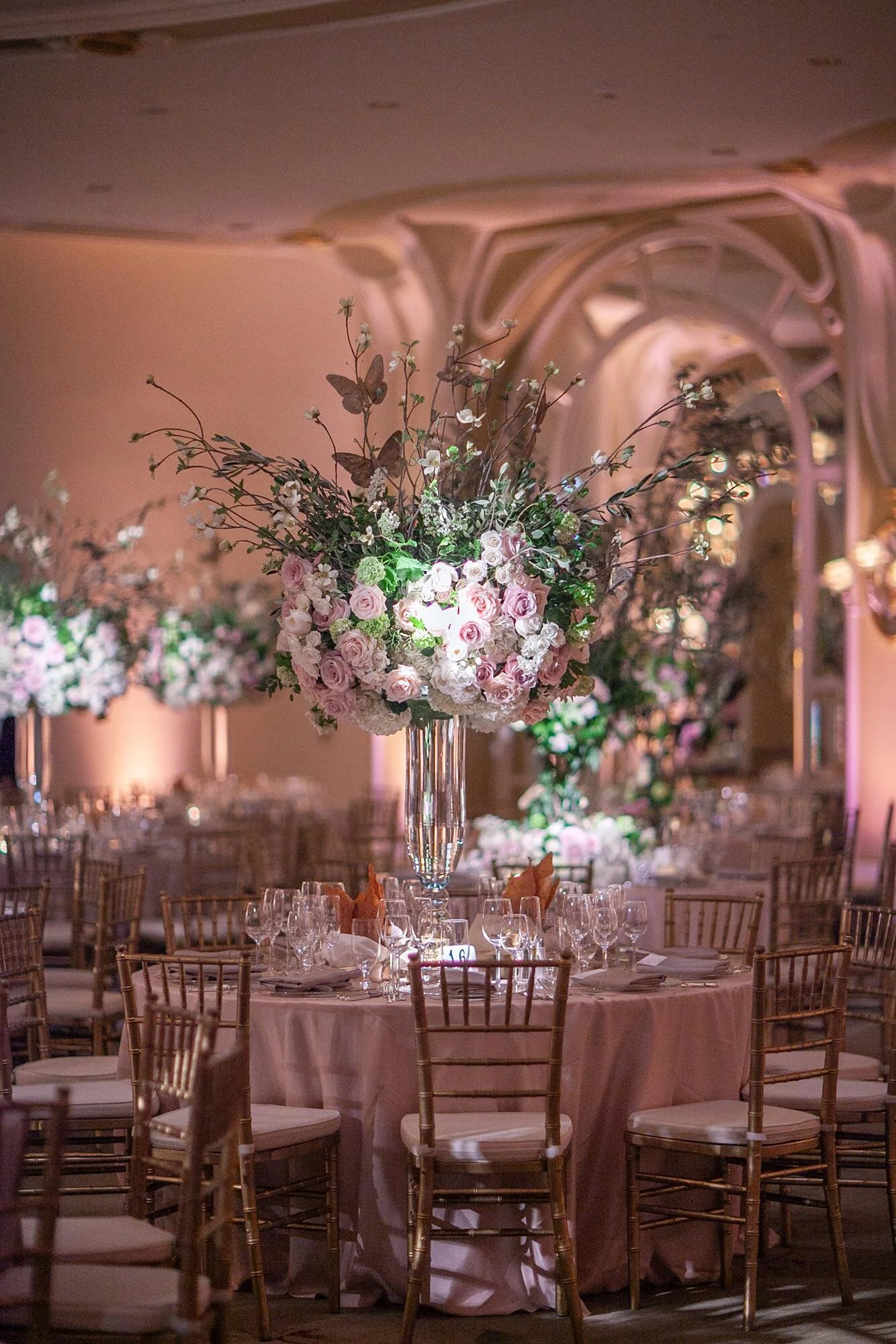 Wedding reception centerpiece of pink and white roses with golden butterflies in the Crystal Ballroom at the Beverly Hills Hotel