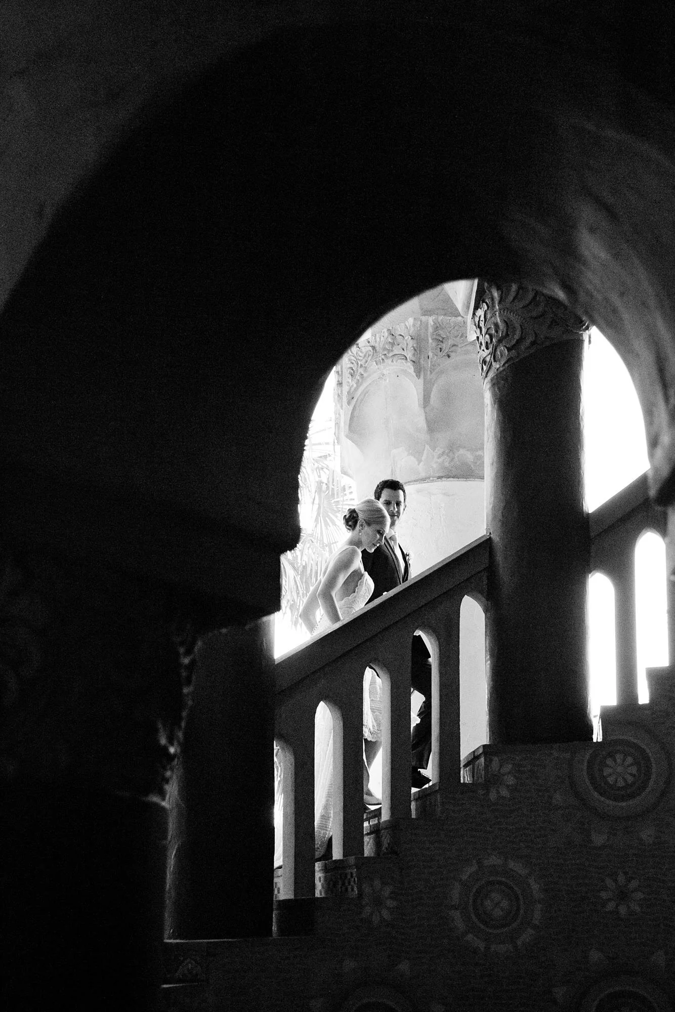 Wedding portrait of bride and groom walking up a staircase at the Santa Barbara Courthouse