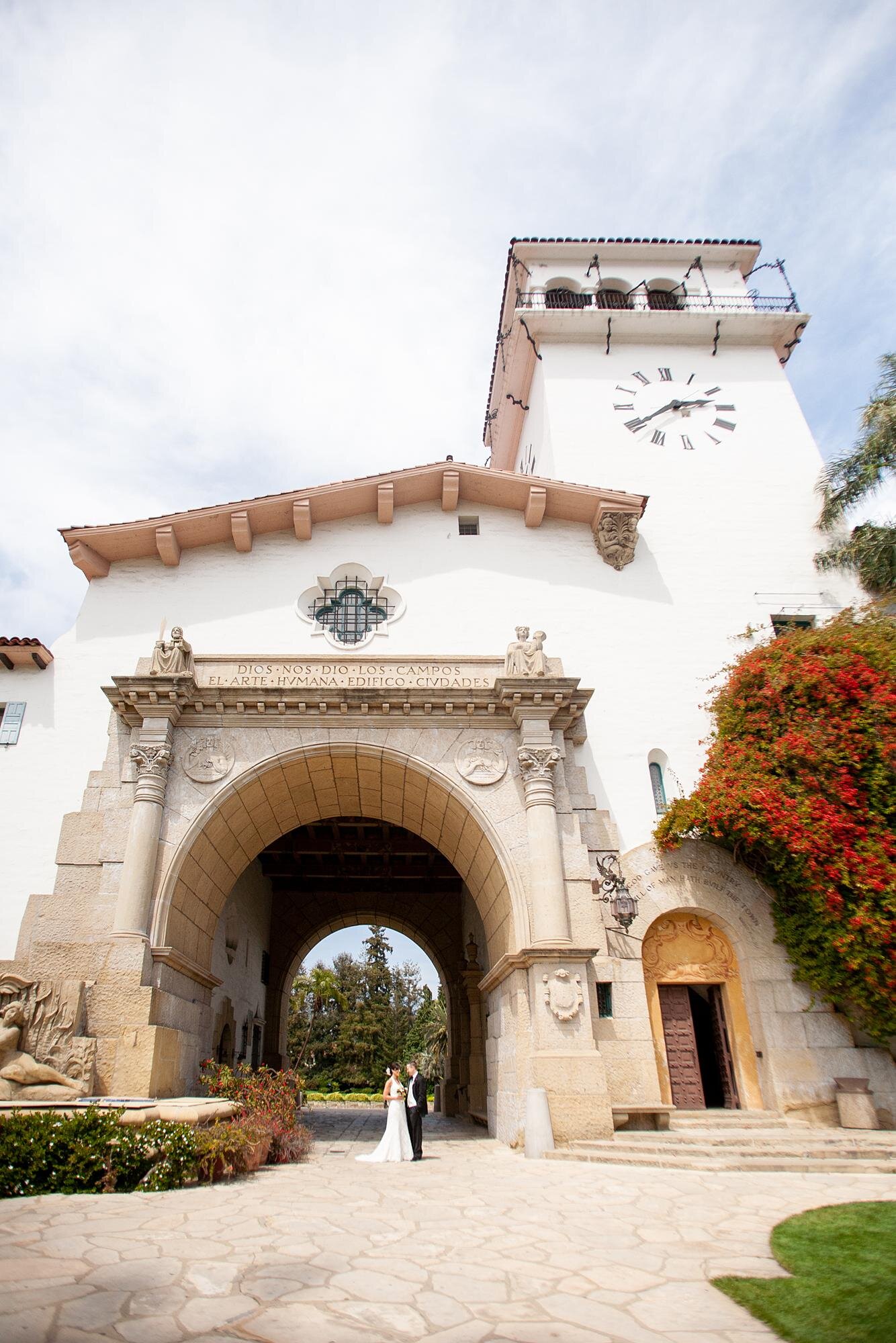 Wedding portrait of a couple beneath the Clocktower arch at the Santa Barbara Courthouse