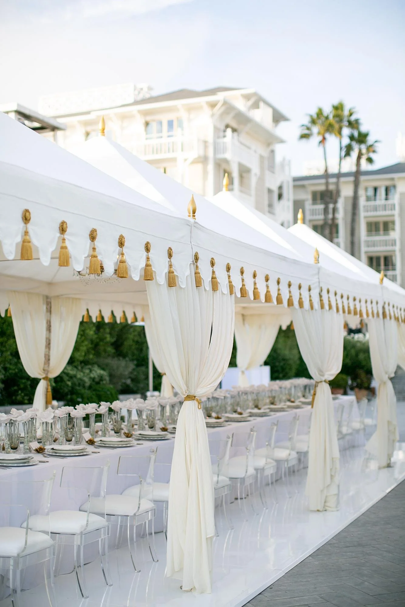 Wedding reception at Shutters on the Beach beneath a white tent over a long banquet table on Pacific Terrace