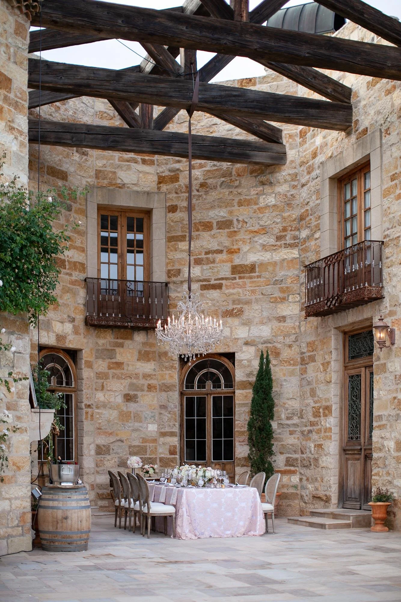 Wedding reception at Sunstone Winery and Villa with outdoor dining beneath a chandelier