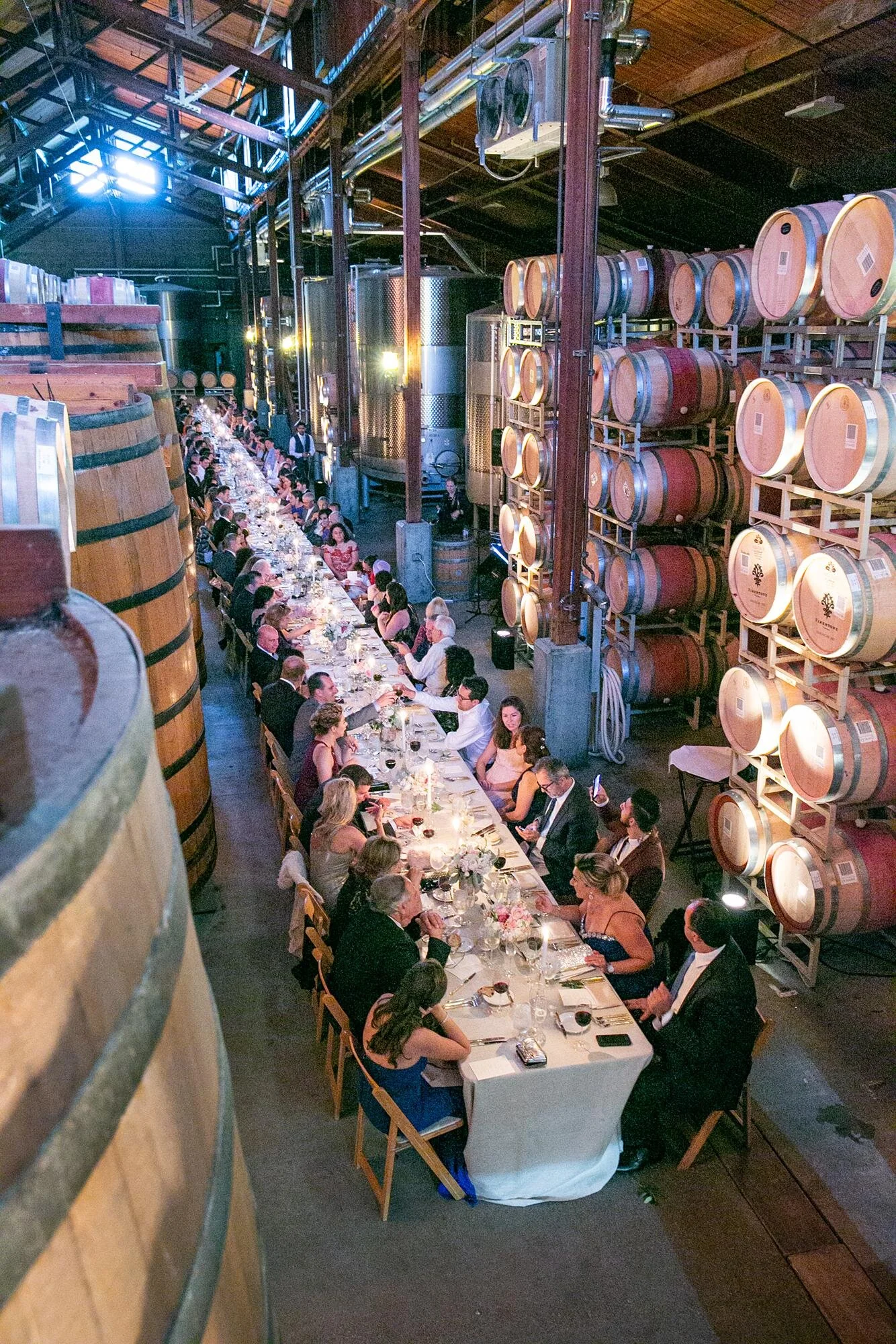 Wedding reception at Firestone Winery with guests dining together in the Barrel Room