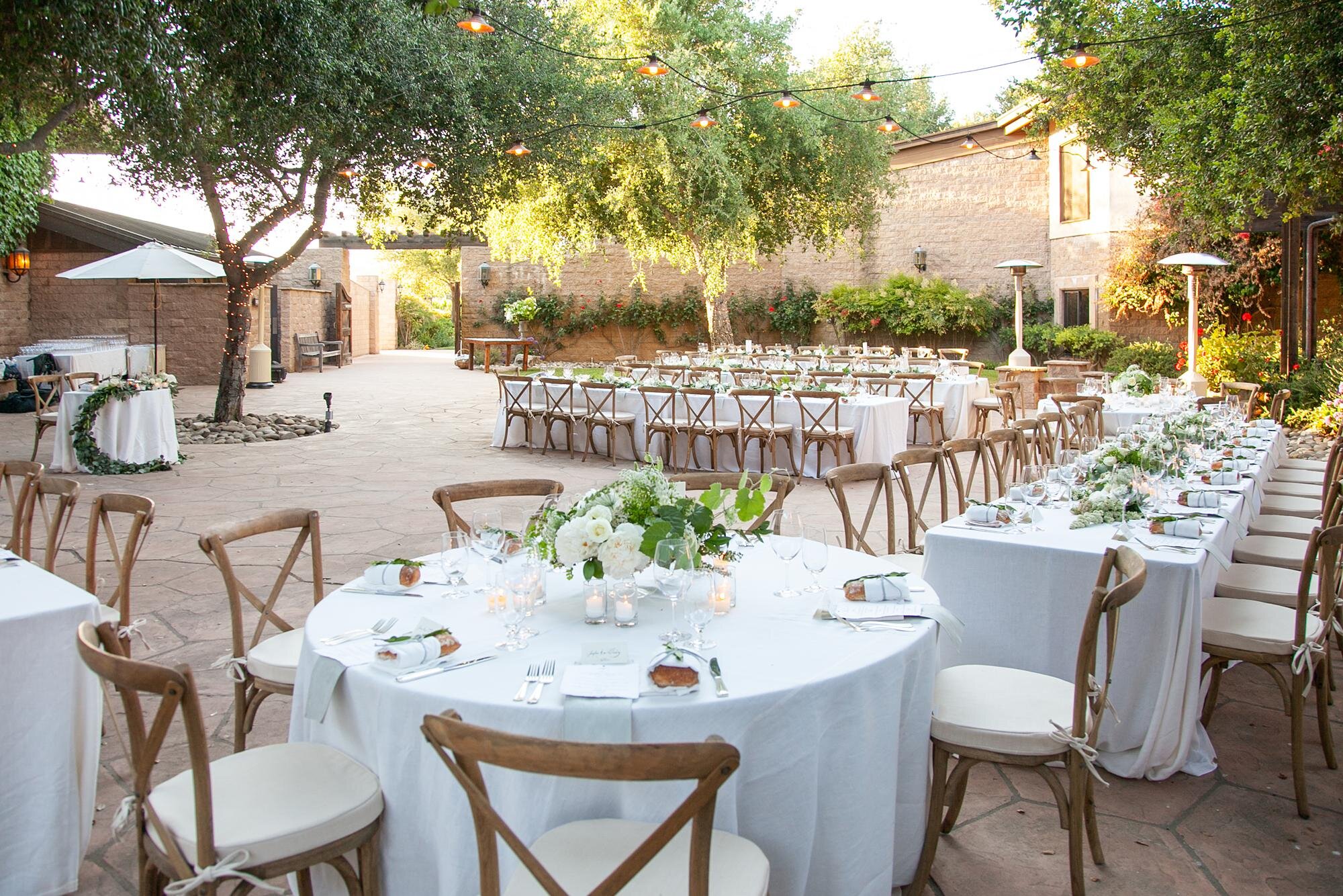Wedding reception at Firestone Winery in the Courtyard with white linens and green centerpieces